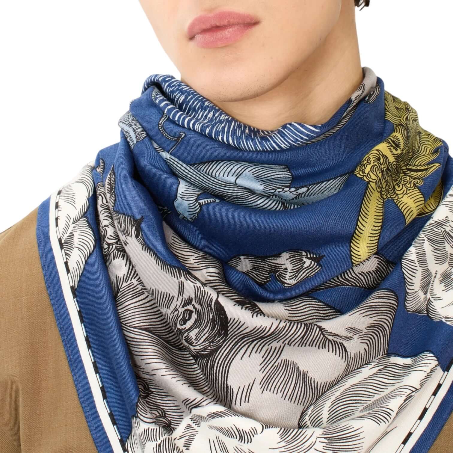 Foulard quadrato blu con stampe uniche, indossato come accessorio di stile su un modello.