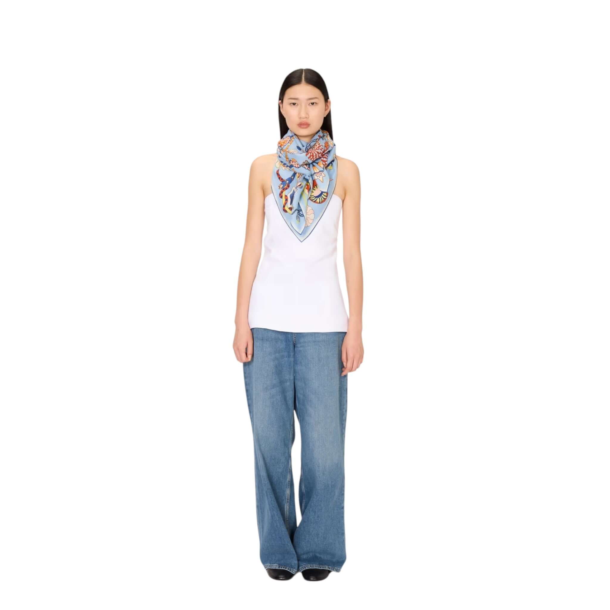 Model wearing Foulard Quadrato Botanique scarf in a stylish outfit, showcasing its vibrant floral design.