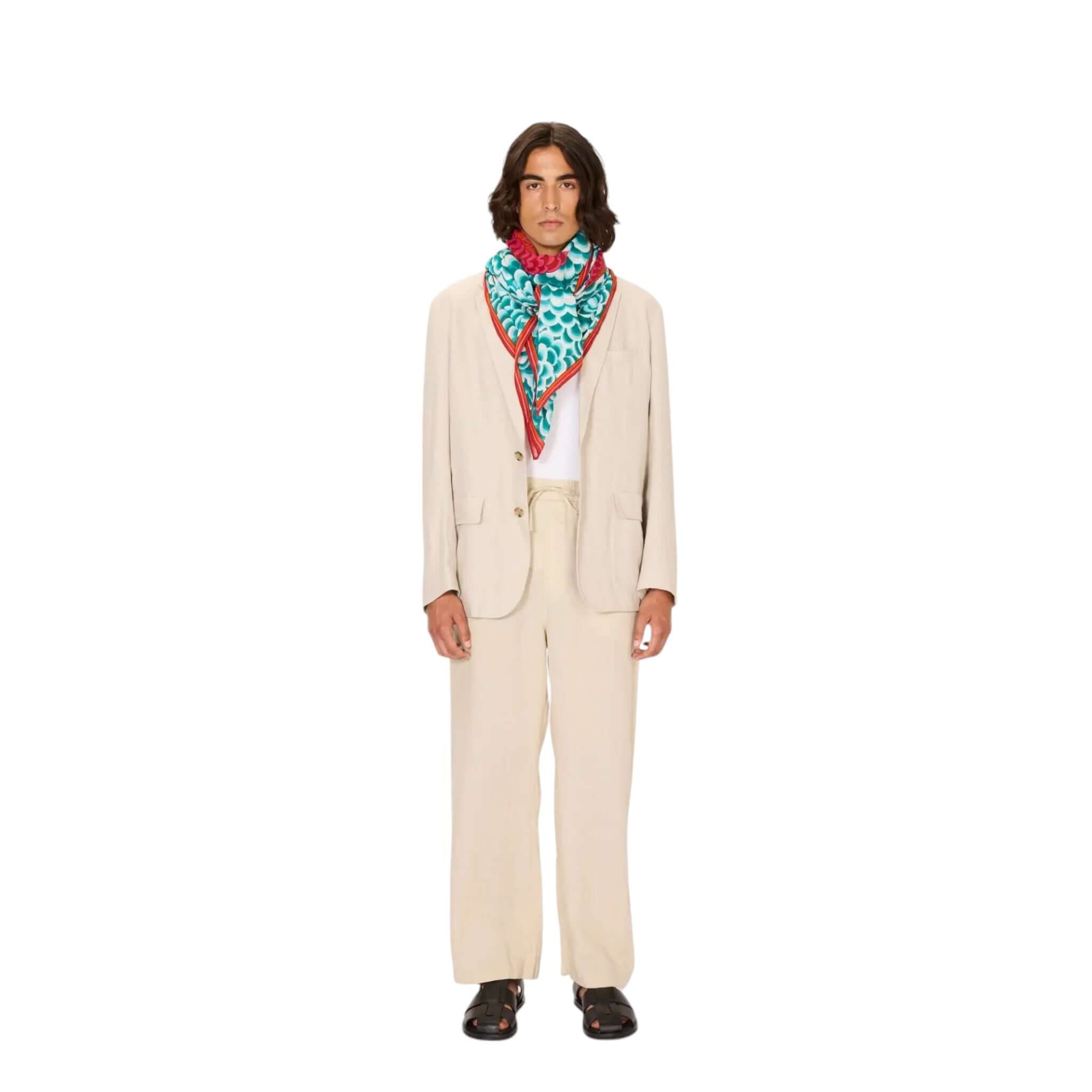 Stylish man wearing a cream suit and a colorful Dragon square foulard, perfect for casual or formal occasions.