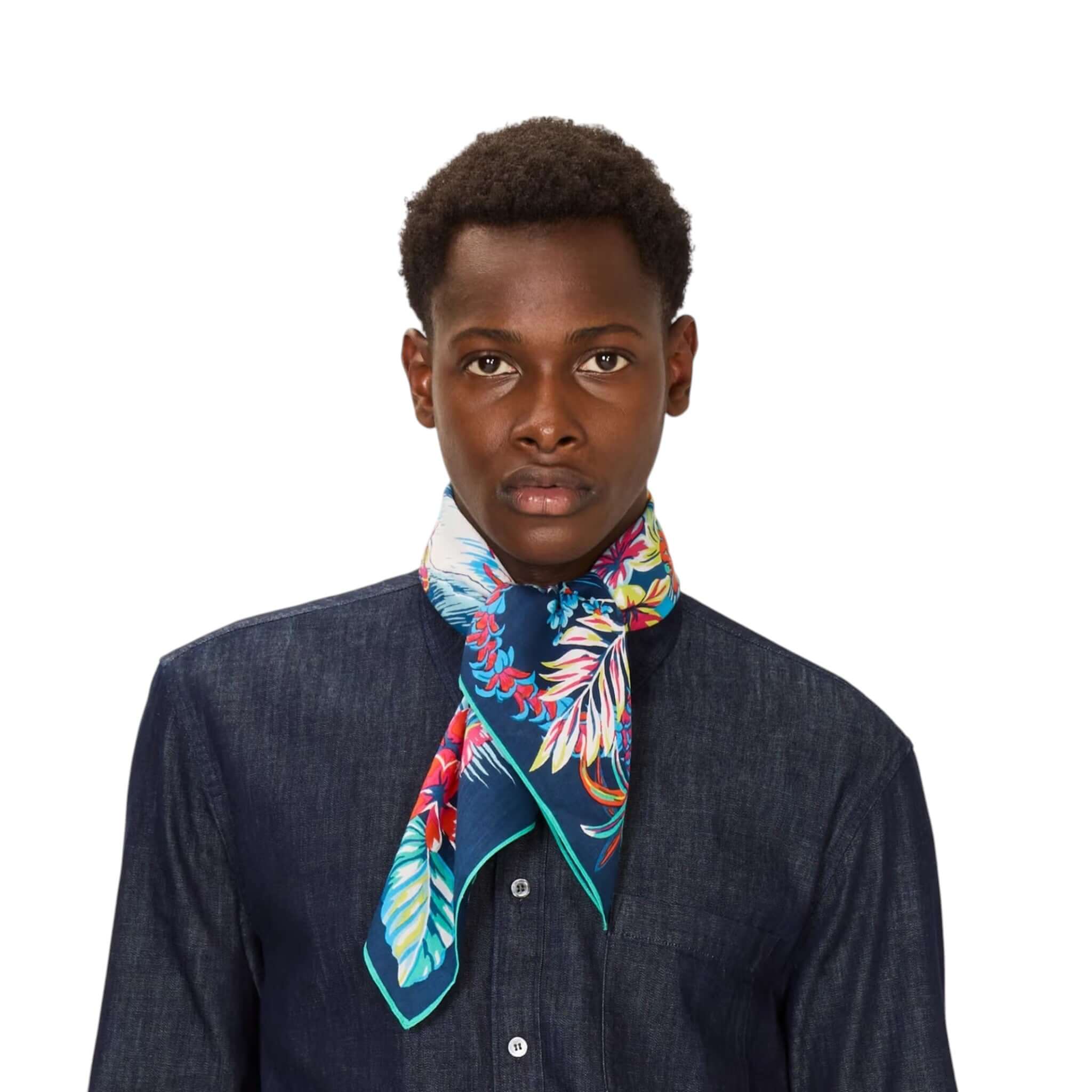Foulard quadrato Hawai indossato al collo da uomo, con design floreale colorato su sfondo blu.