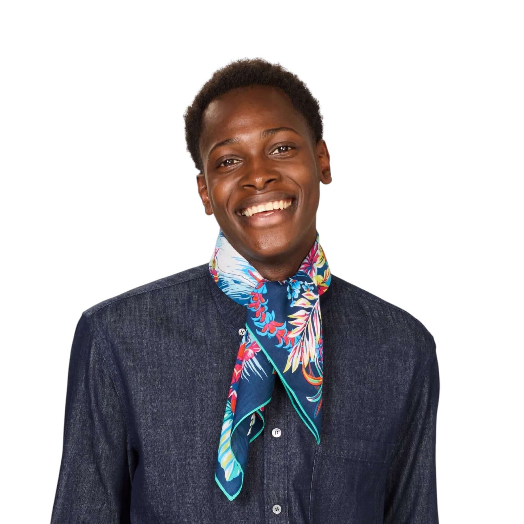 Man wearing a colorful Foulard Quadrato Hawai scarf, showcasing its vibrant print and stylish wear.