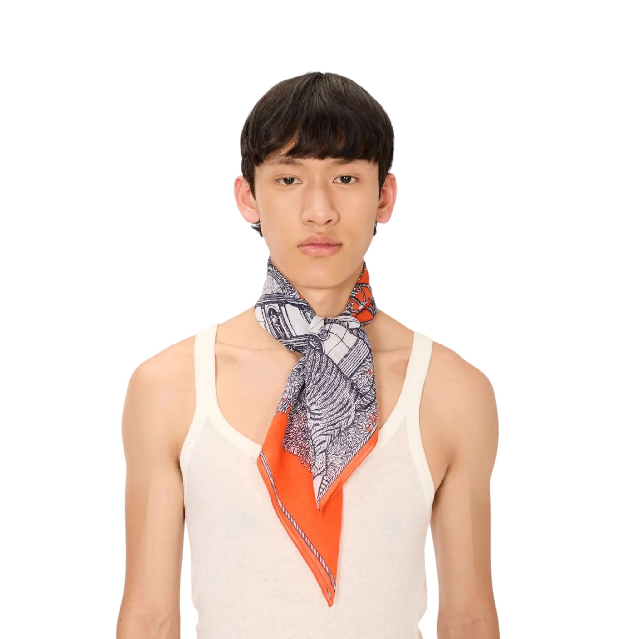 Foulard Quadrato Mirage indossato da giovane, con design stampato a mano e tonalità arancioni e nere.