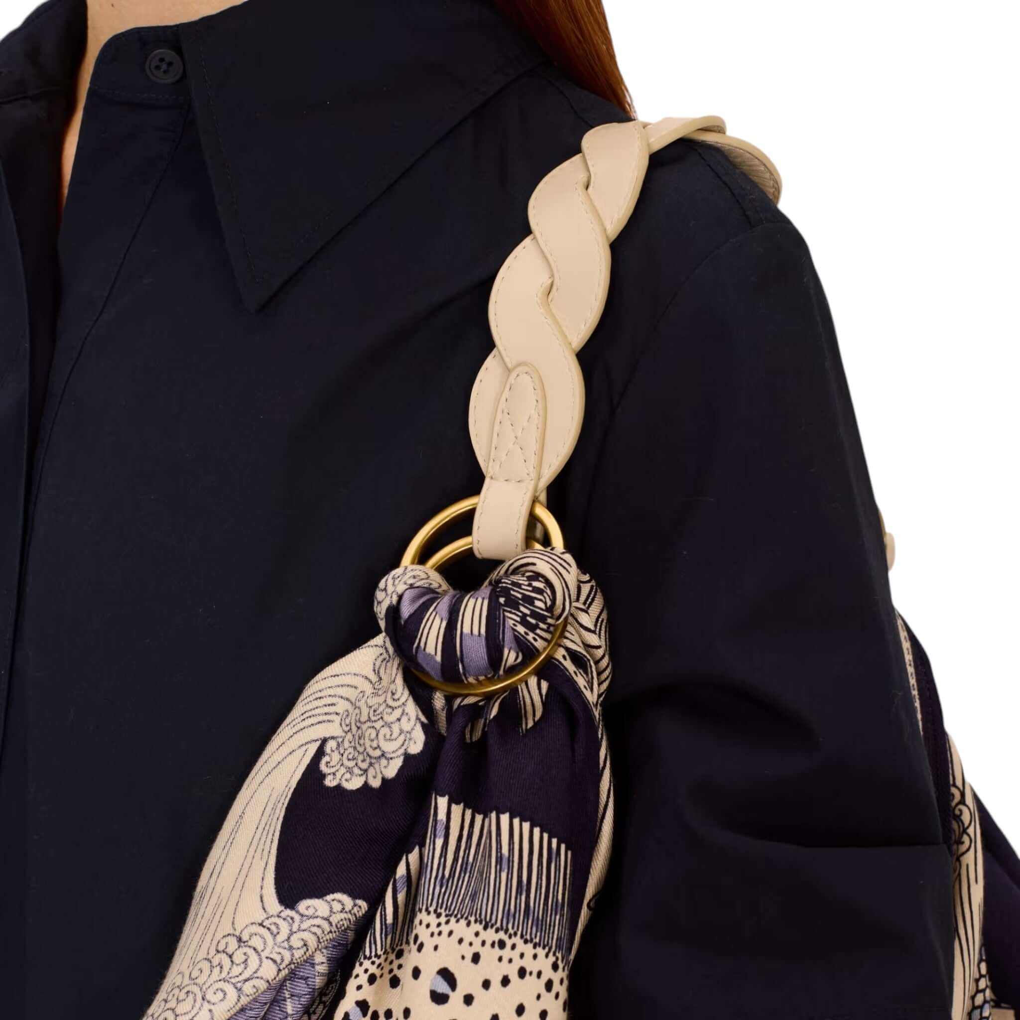 Fashionable woman carrying a stylish bag with a silk foulard, showcasing elegant design and craftsmanship.