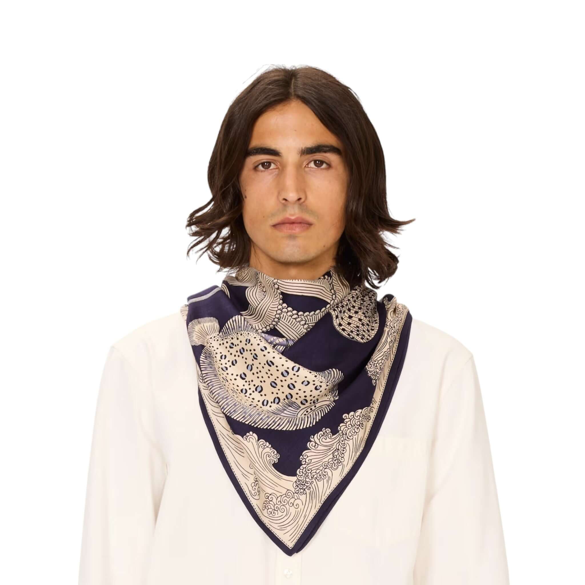 Foulard Quadrato Poseidon in seta modal con disegno elegante su sfondo navy indossato da un uomo.