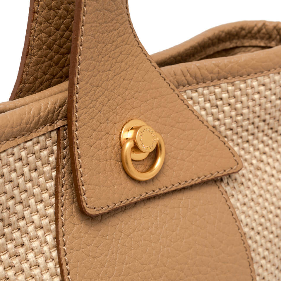 Close-up of Gianni Chiarini Firenze Ester bag detail featuring woven straw and gold decorative ring.