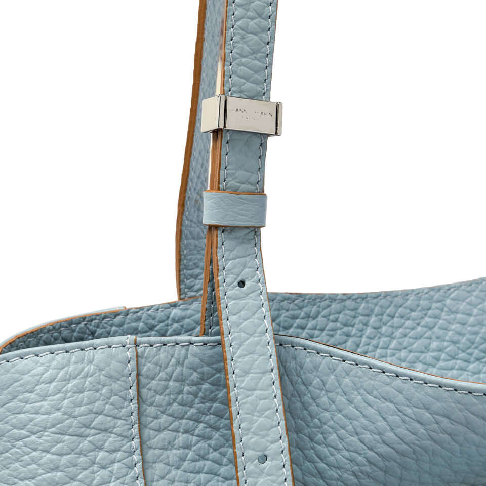 Detail of Minerva handbag in soft blue leather, showcasing its strap and stitching.