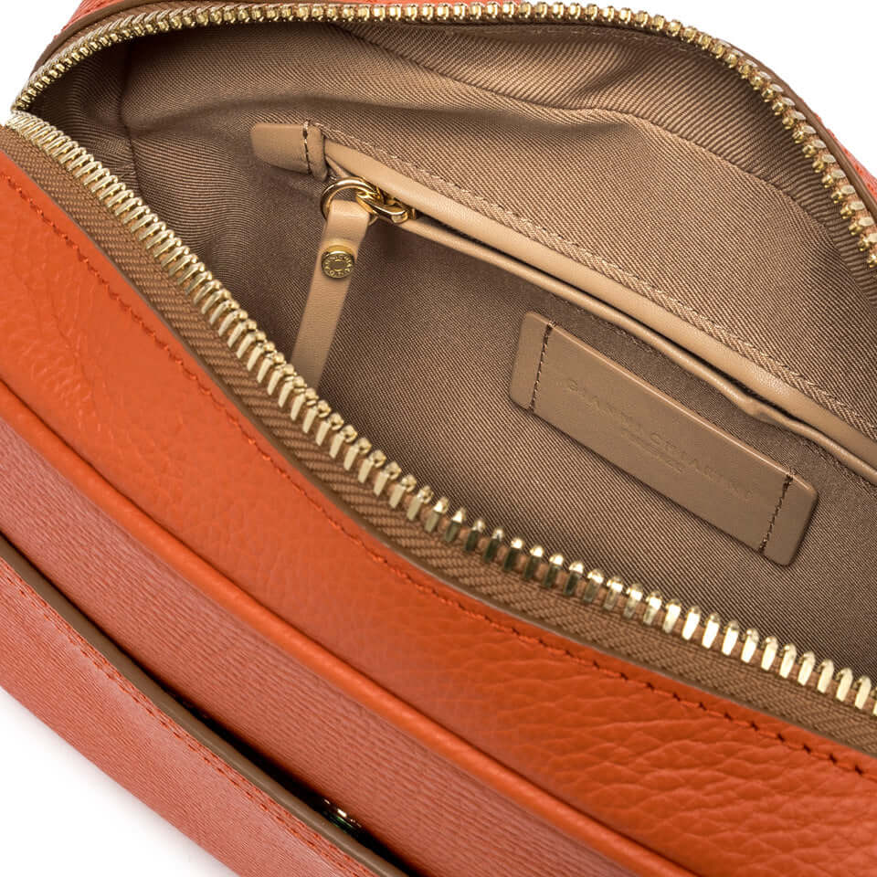 Inside view of the Nina by Gianni Chiarini Firenze bag featuring a zip pocket and smooth lining in a warm orange color.