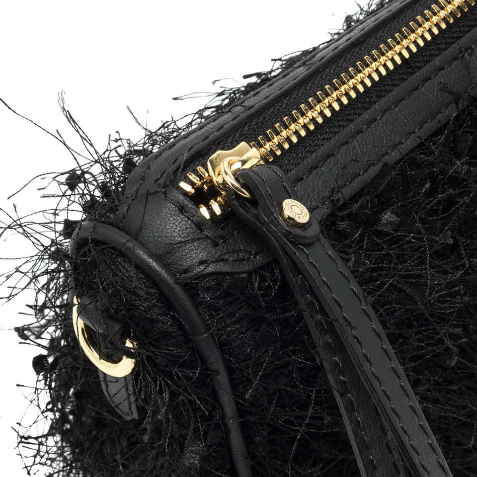Close-up of the black Nora Pouch by Gianni Chiarini, showcasing frayed fabric, leather details, and gold zipper.
