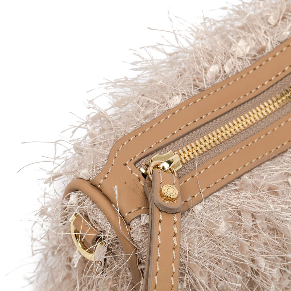 Close-up of Nora Pouch by Gianni Chiarini showing fringed fabric and leather zipper details.