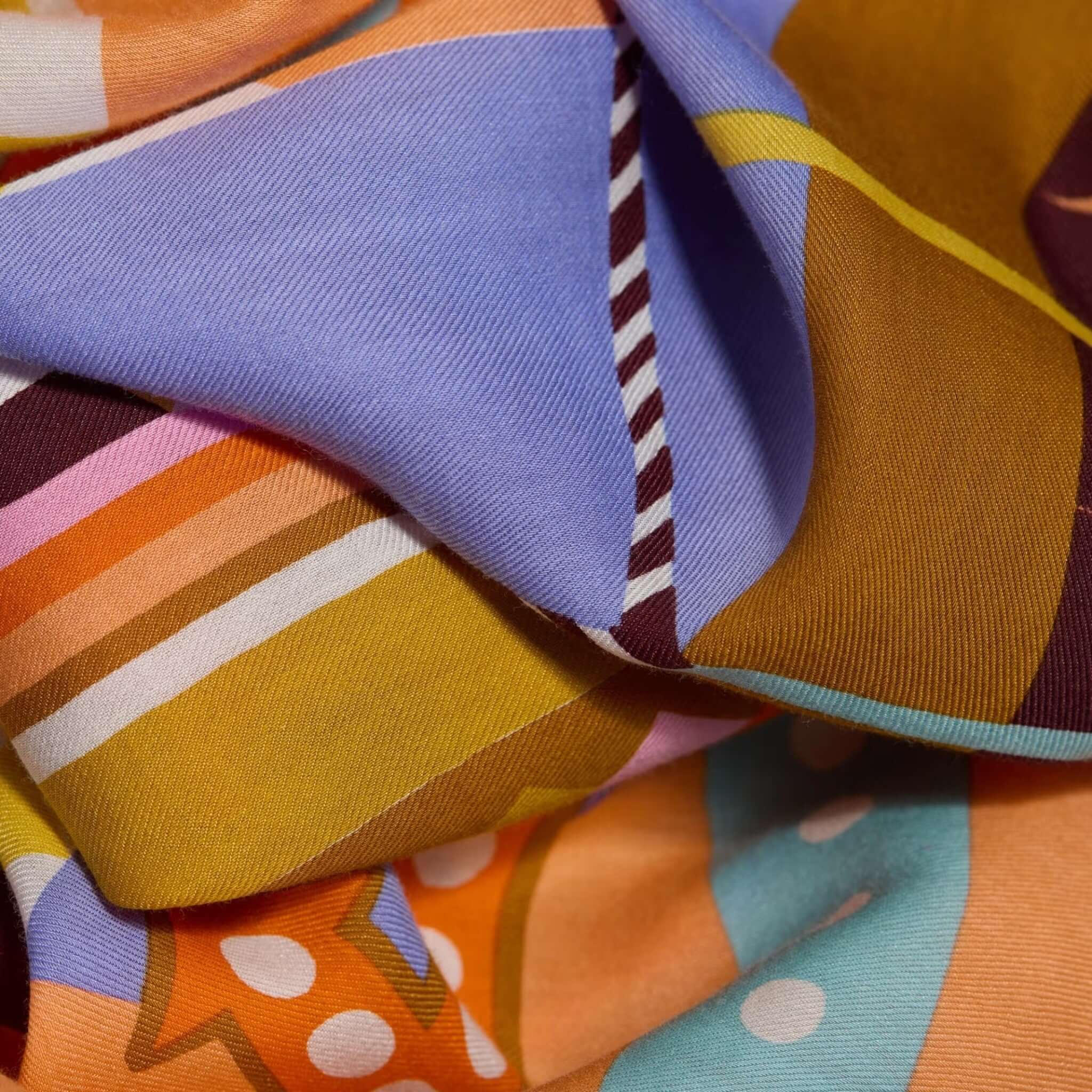 Close-up of colorful hand-printed scarf from the Sciarpa Rollercoaster collection, showcasing vibrant patterns and textures.