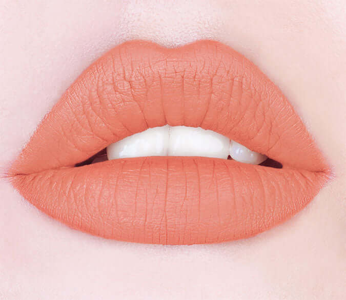Close-up of perfectly shaped lips wearing Rossetto creamy lipstick in a soft peach shade.