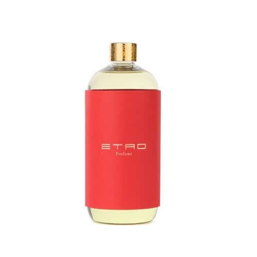 Etro Perfume bottle with red label and golden cap, showcasing a luxury fragrance experience.
