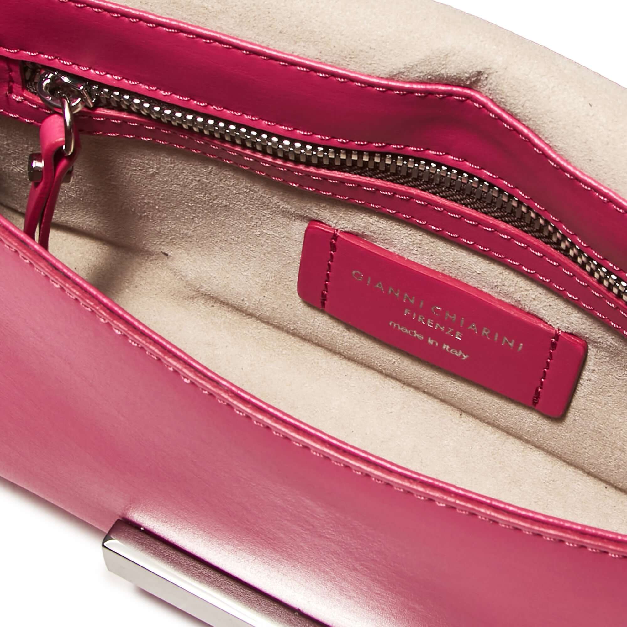 Interno della clutch Lily di Gianni Chiarini, in pelle liscia fucsia con cerniera e etichetta di fabbricazione.