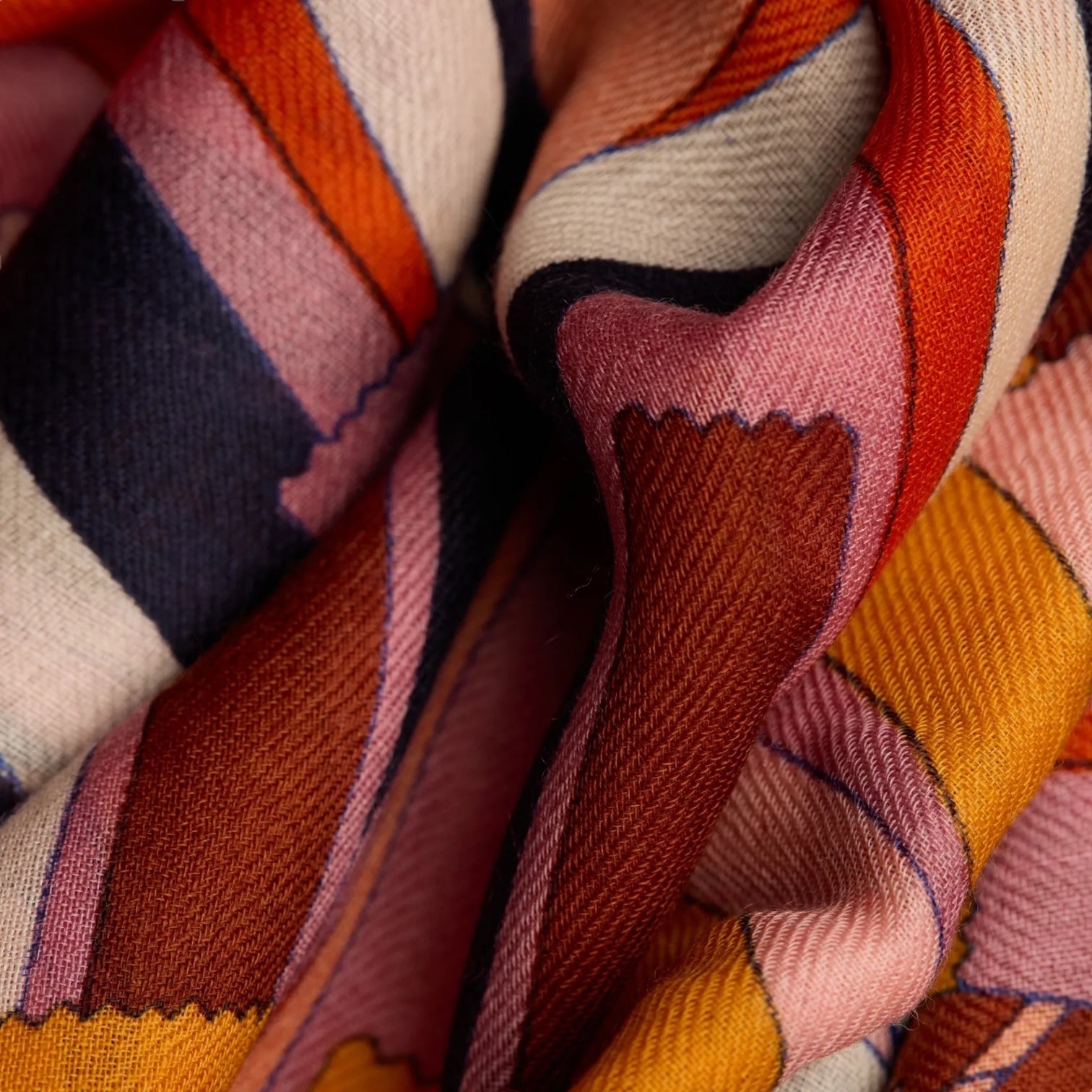 Colorful patterned fabric of the Sciarpa Sirocco Arancione scarf, showcasing unique design and texture.