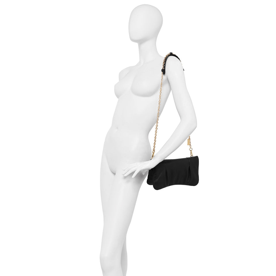 Chic black laminated leather handbag Glenda with gold chain strap displayed on a mannequin.