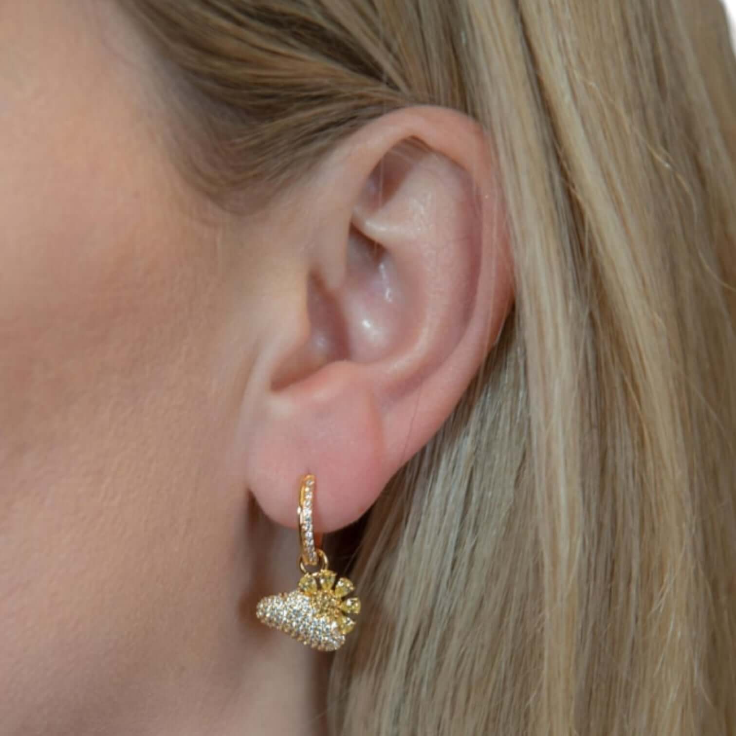 Eleganti orecchini in oro 18 carati con design unico, indossati da una donna. Style chic e raffinato.