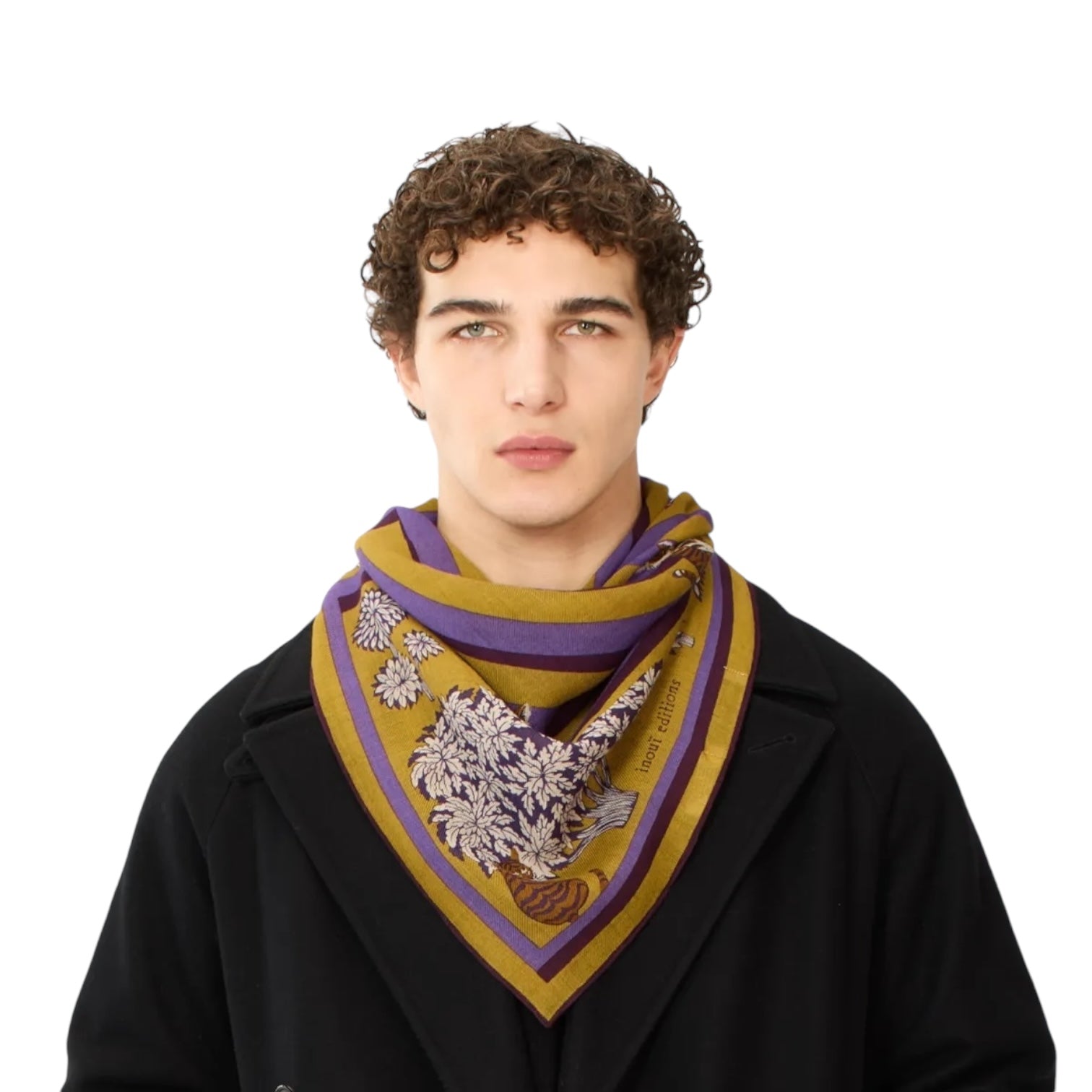 Man wearing the Foulard Quadrato Labyrinthe Viola, a 100x100 vibrant square scarf with unique floral designs.