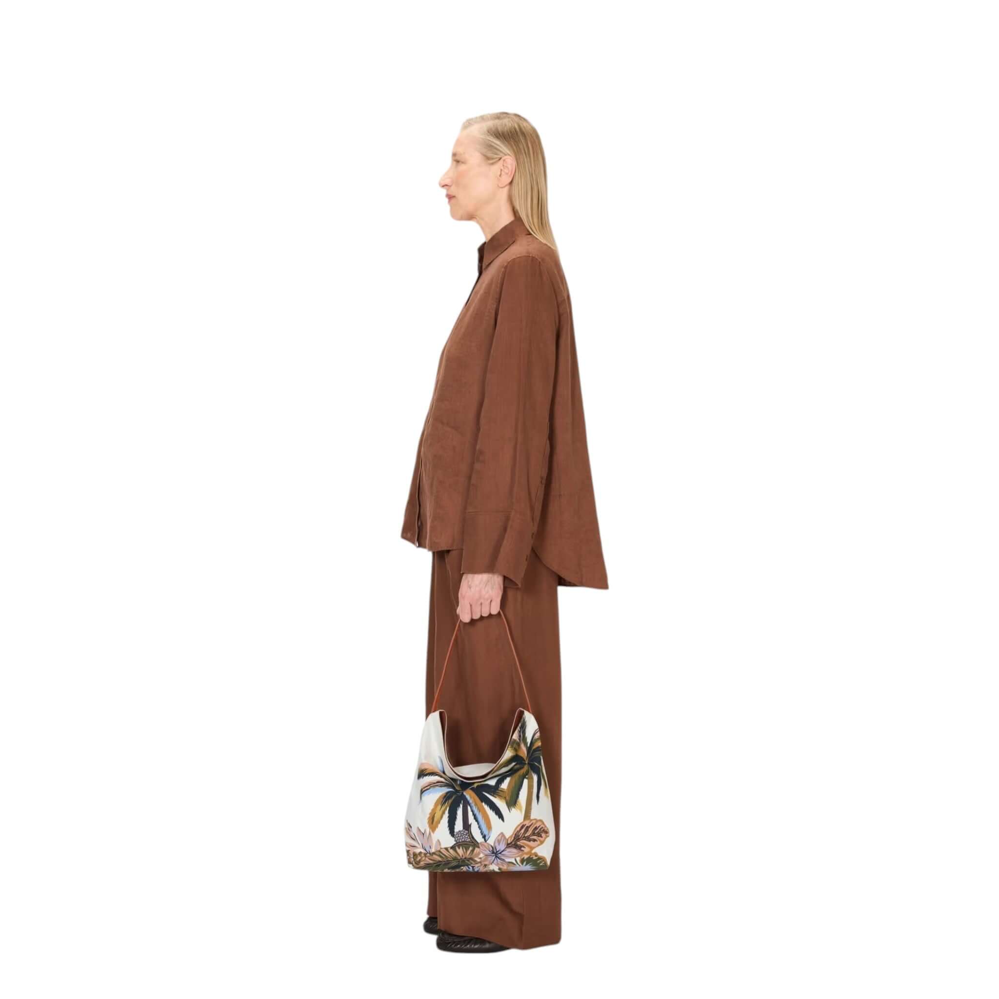 Modella in abbigliamento marrone con borsa Campus Hawai in cotone e pelle, in stile minimalista e moderno.