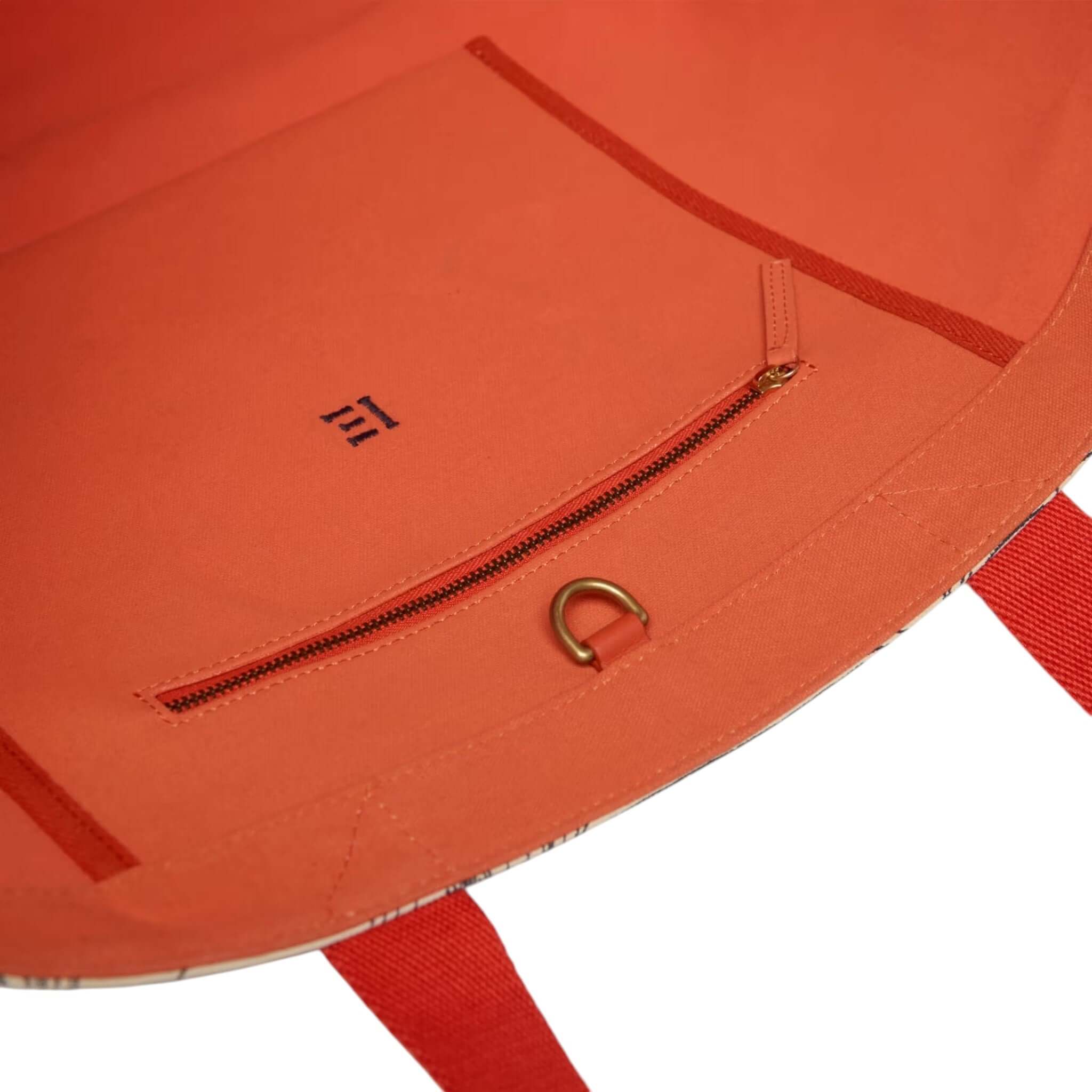 Interno della borsa Carrier Poseidon con tasca zip in tessuto arancione per accessori e oggetti personali.