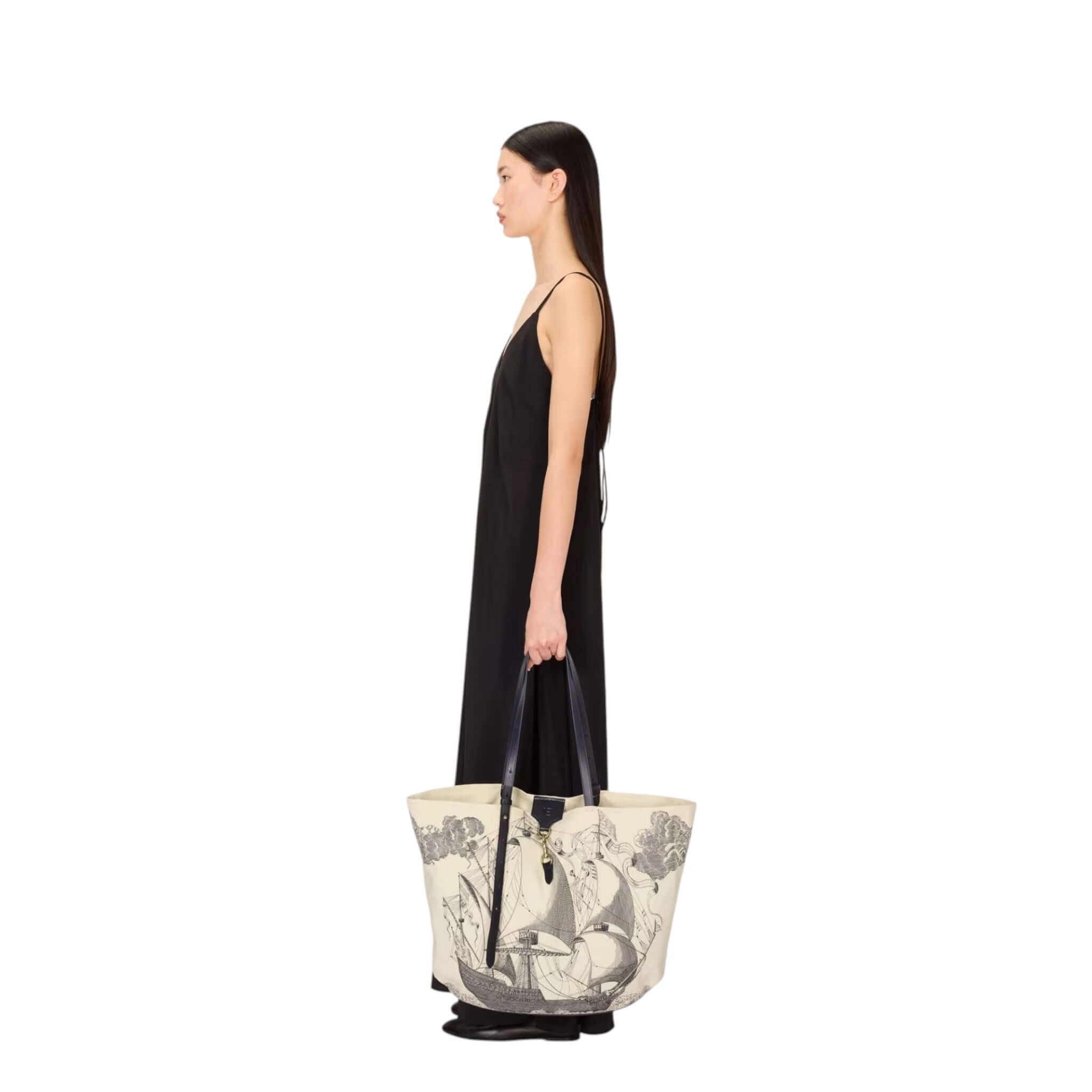 Donna in abito nero che porta la borsa Shopping Des Rives Et Des Reves, in cotone e pelle, design elegante.
