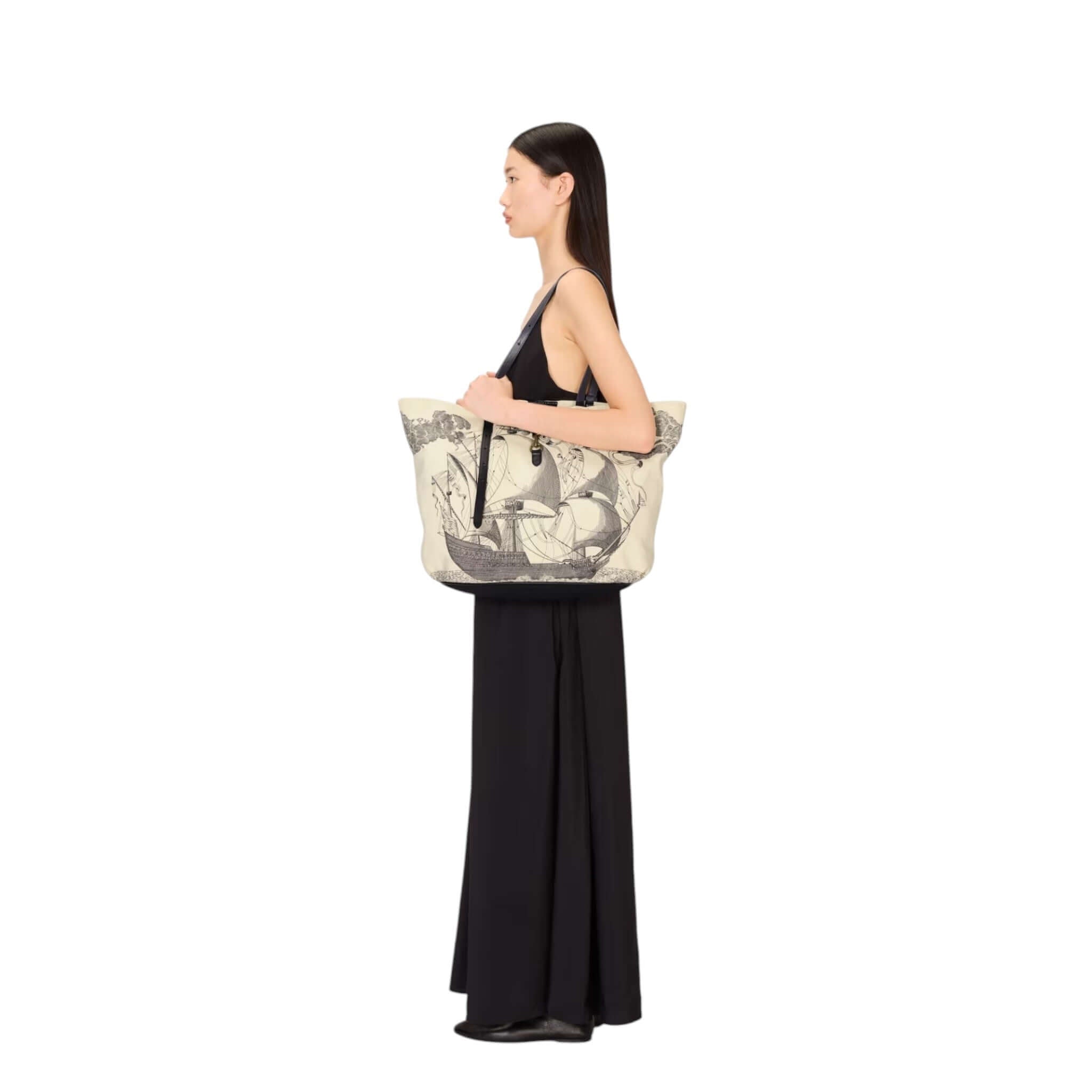 Model showcasing the Borsa Shopping Des Rives Et Des Reves, a large cotton bag with unique design and leather handle.