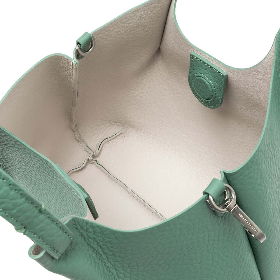 Interior view of DUA handbag in mint green leather, featuring spacious design and magnetic closure.