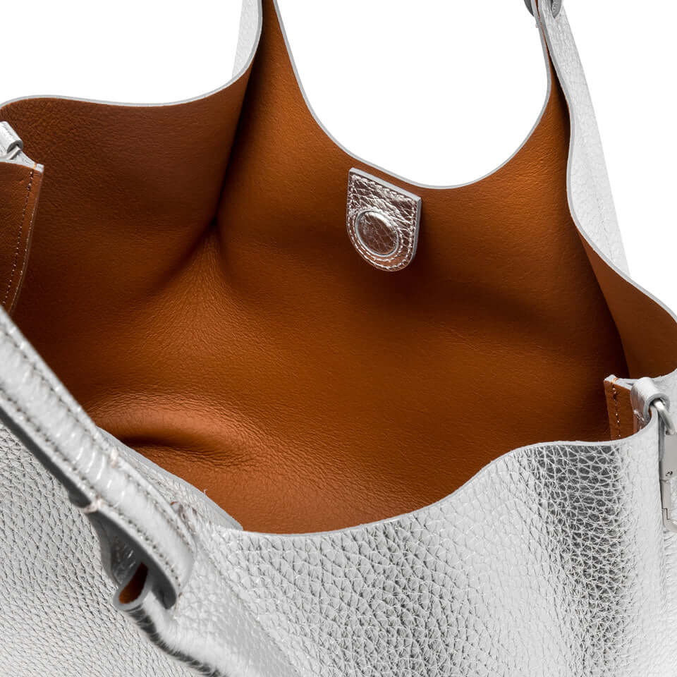 Inside view of the DUA bag showcasing silver leather and brown interior with magnetic closure.
