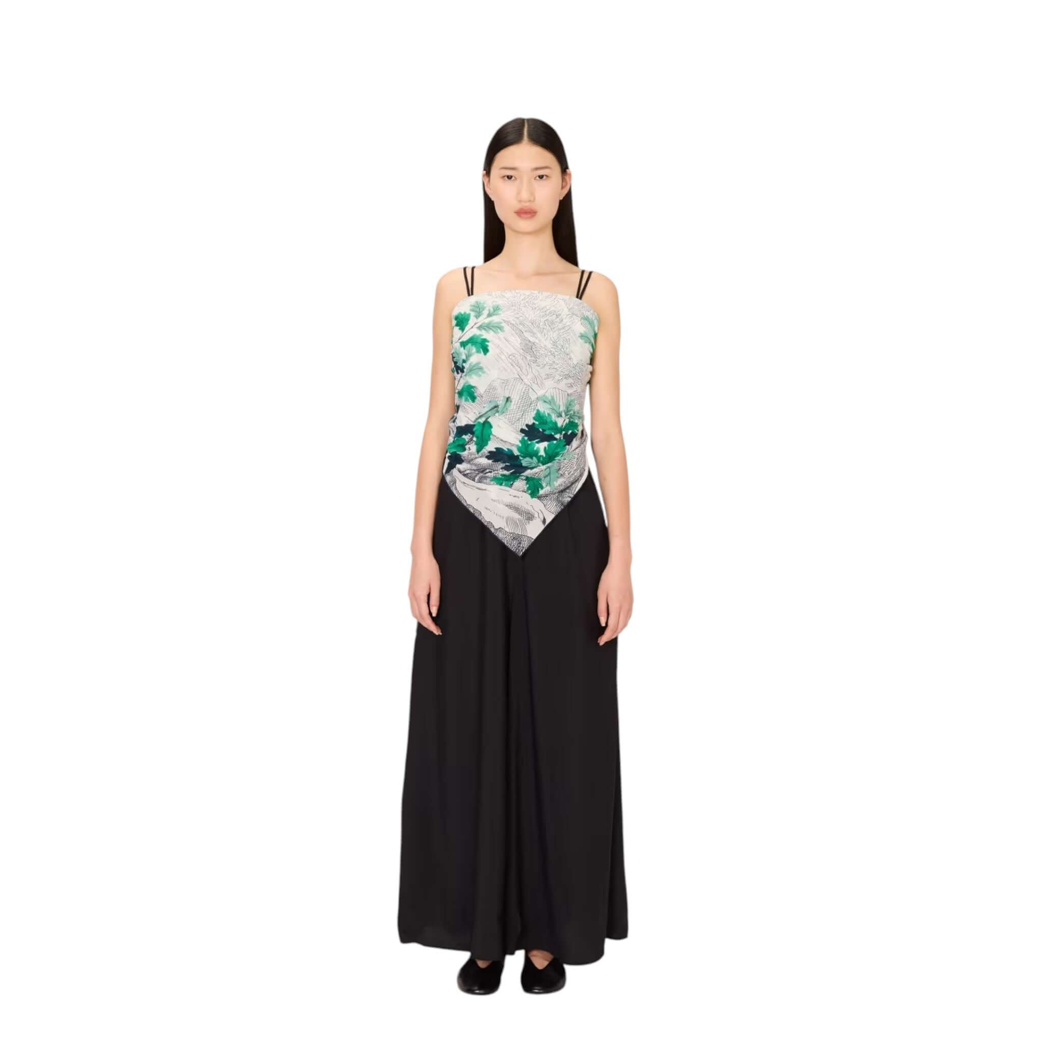 Model wearing a stylish black and patterned dress, showcasing elegant design and modern fashion aesthetics.