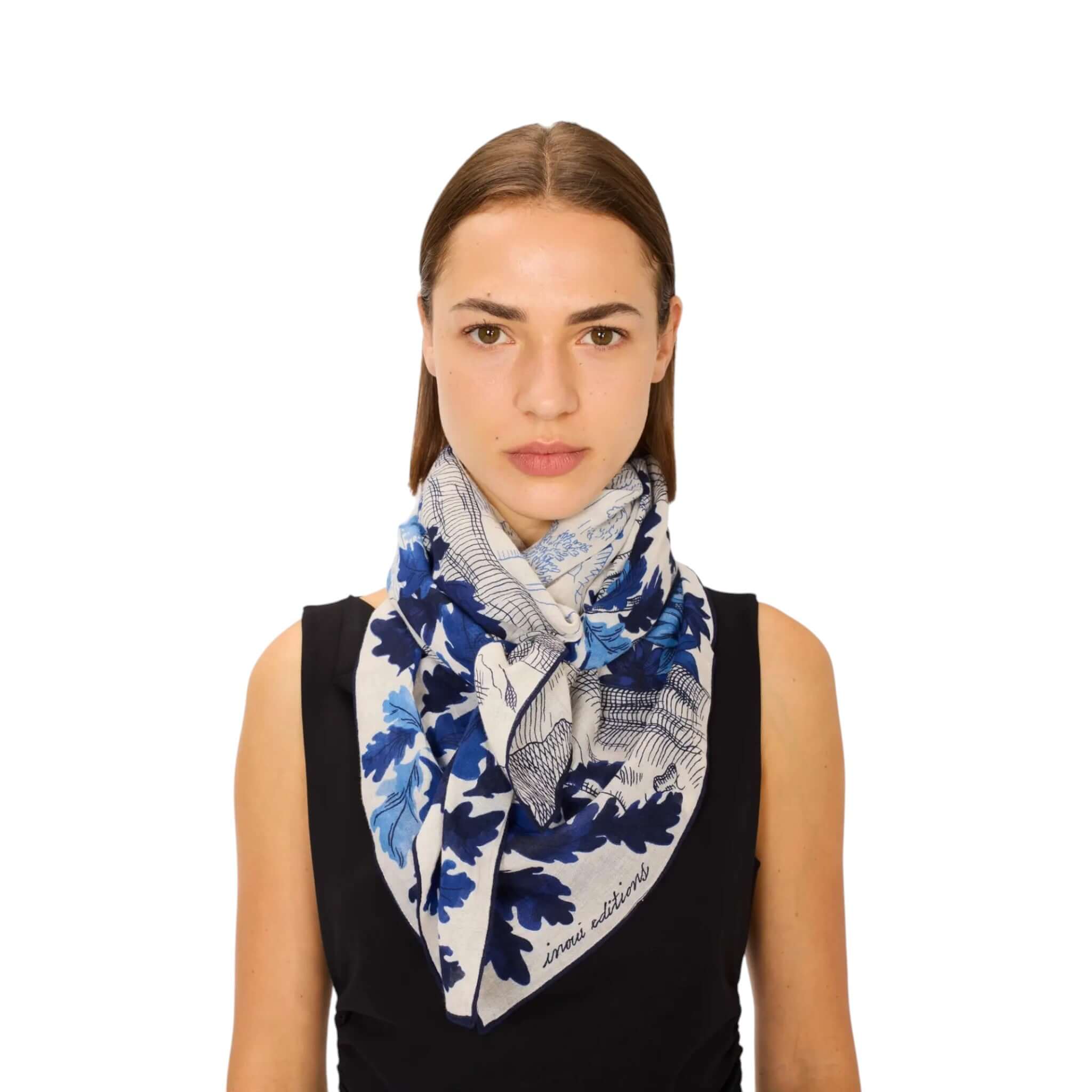 Foulard Quadrato Amboise in blu e bianco con foglie, indossato da una donna su sfondo bianco.