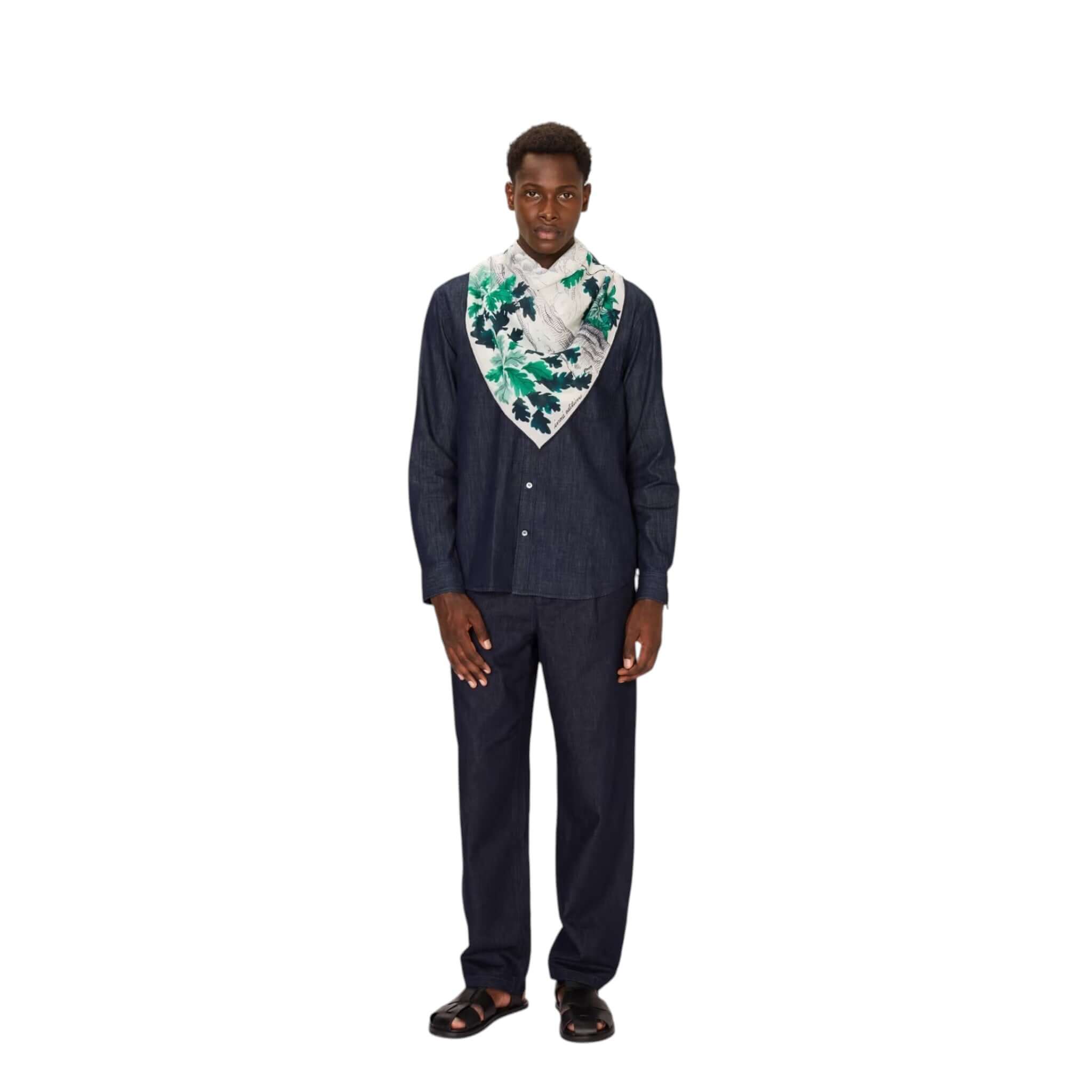 Man wearing Foulard Quadrato Amboise, featuring colorful floral design, paired with a dark shirt and trousers.