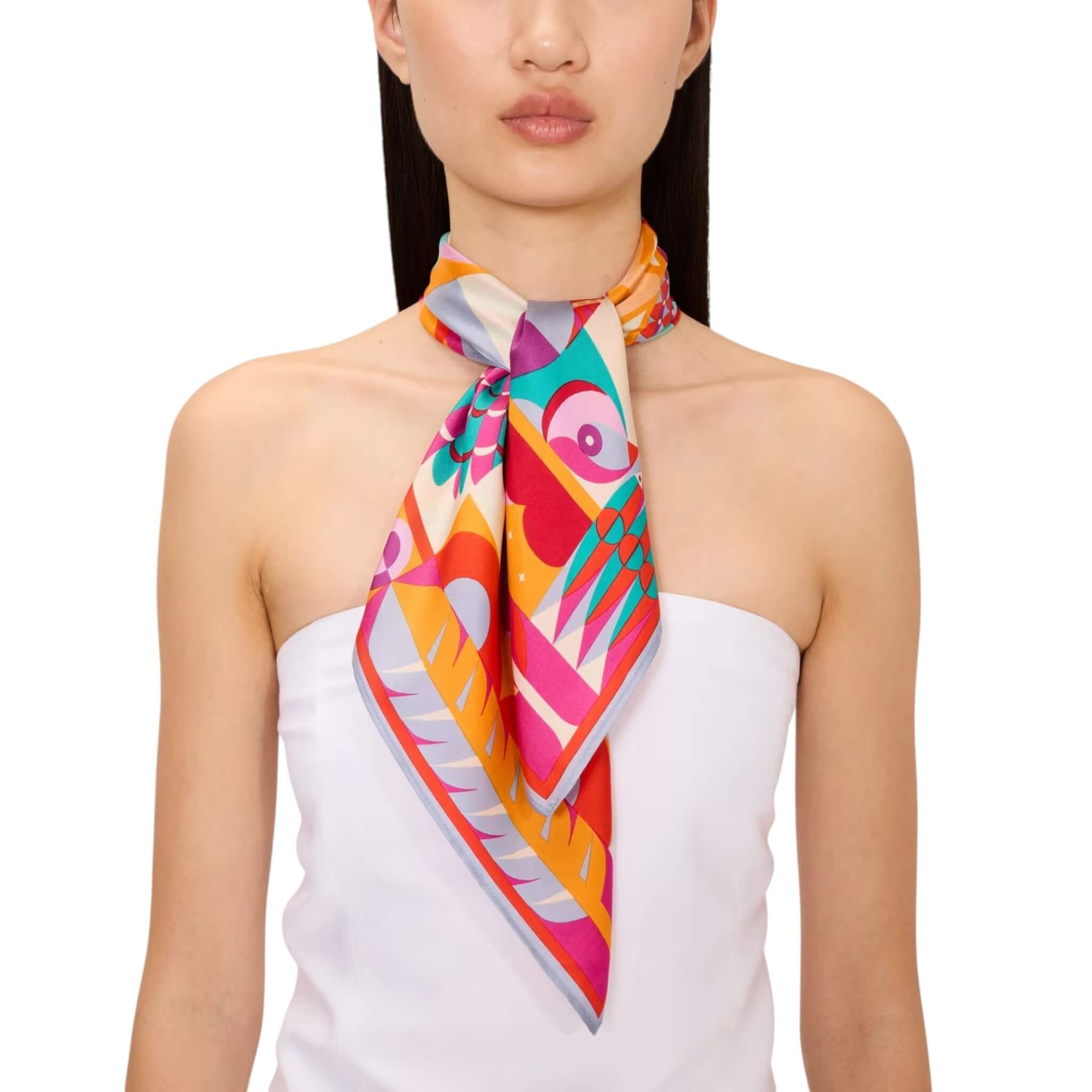 Colorful silk foulard Cleo elegantly styled around the neck, showcasing unique patterns and designs.