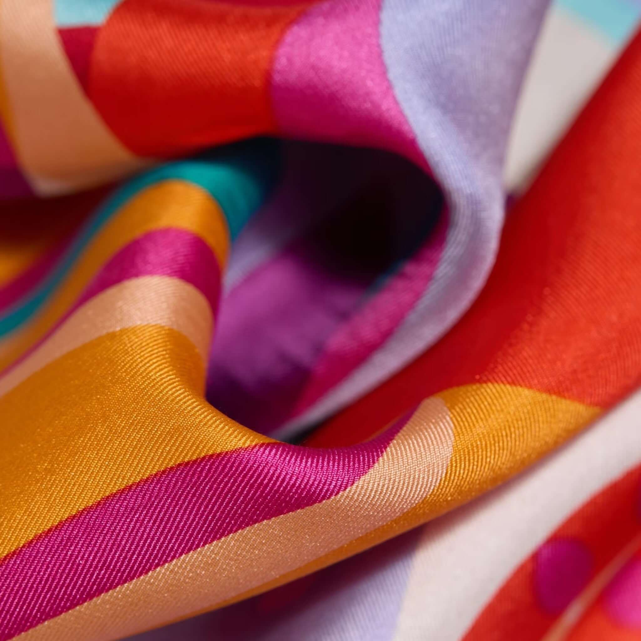 Close-up of Foulard Quadrato Cleo featuring vibrant patterns in silk, showcasing rich colors and silky texture.