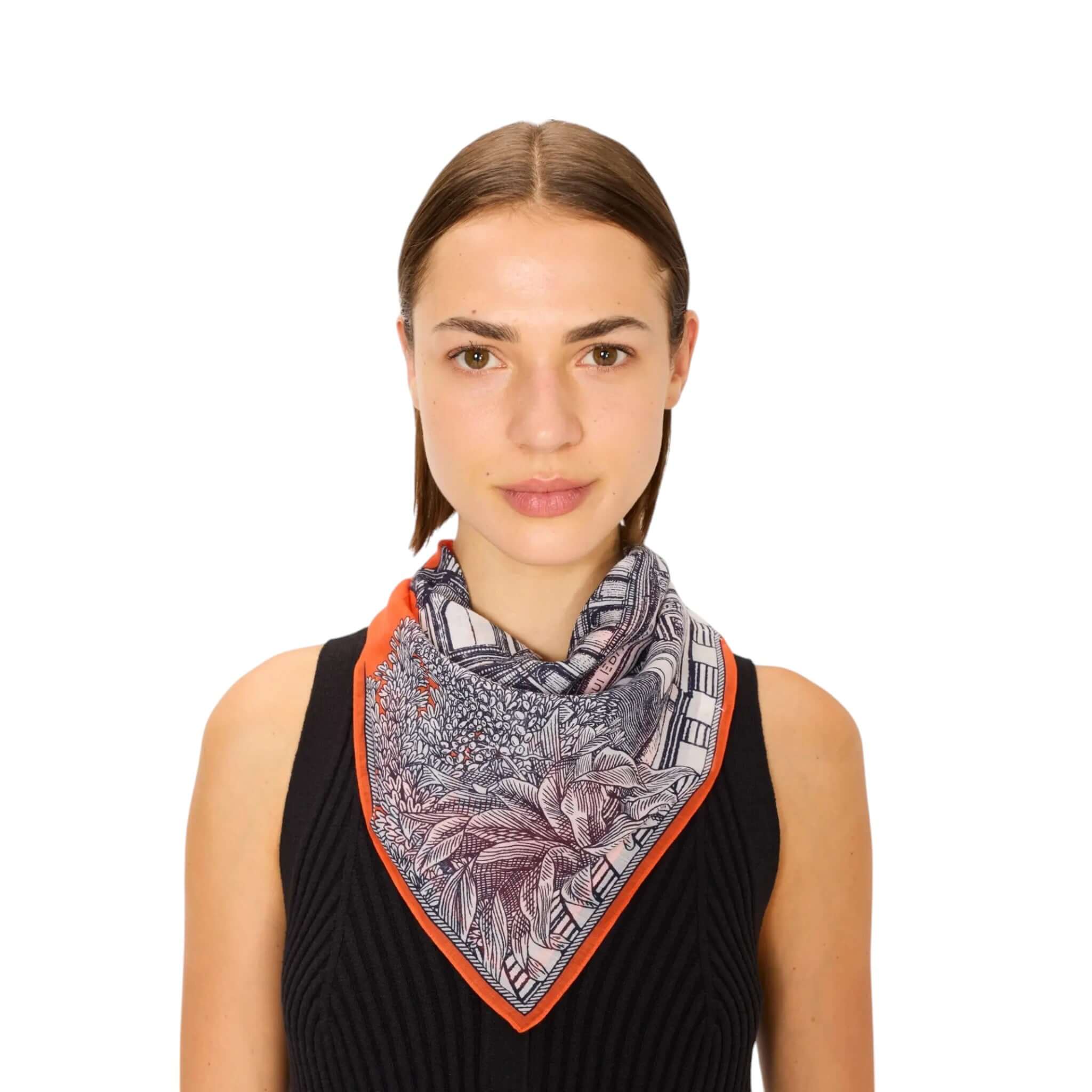Model wearing Foulard Quadrato Mirage, a hand-printed scarf in floral design, perfect for stylish accessorizing.