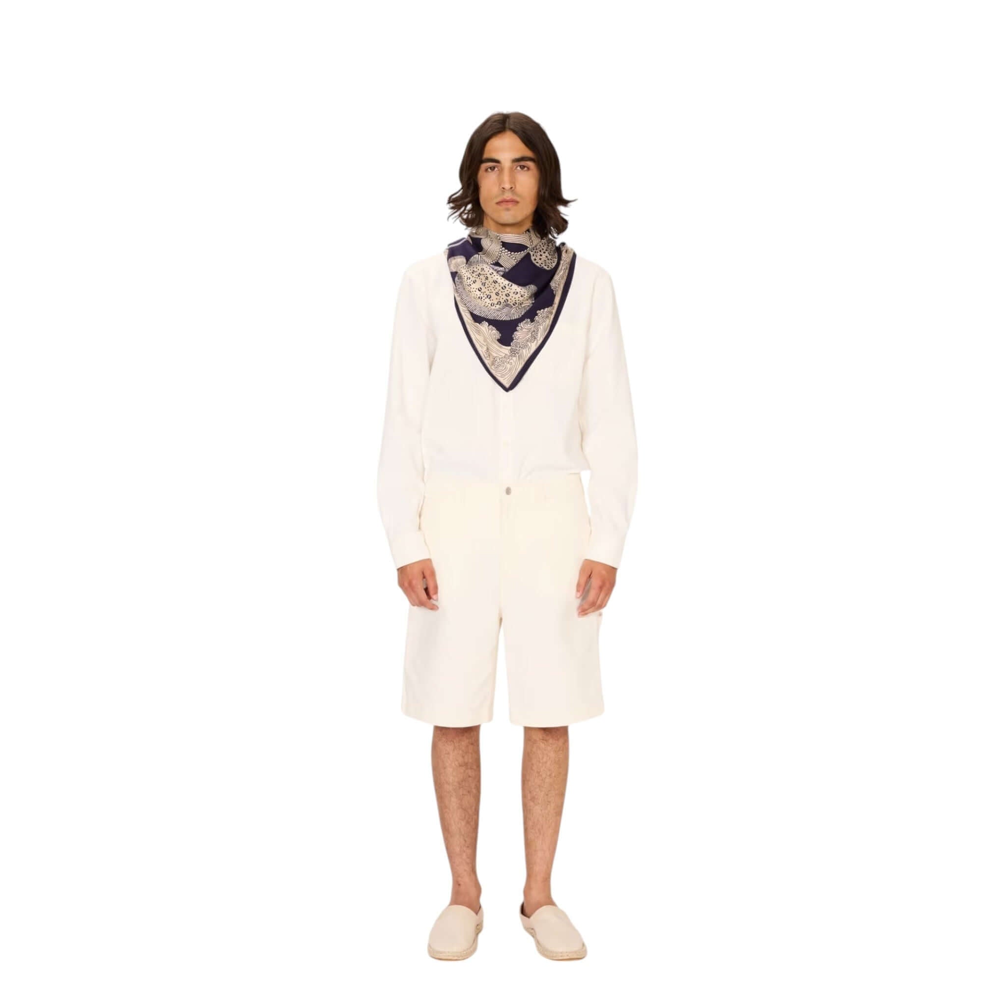 Man wearing the Foulard Quadrato Poseidon, a hand-printed modal silk scarf, styled with a white outfit.