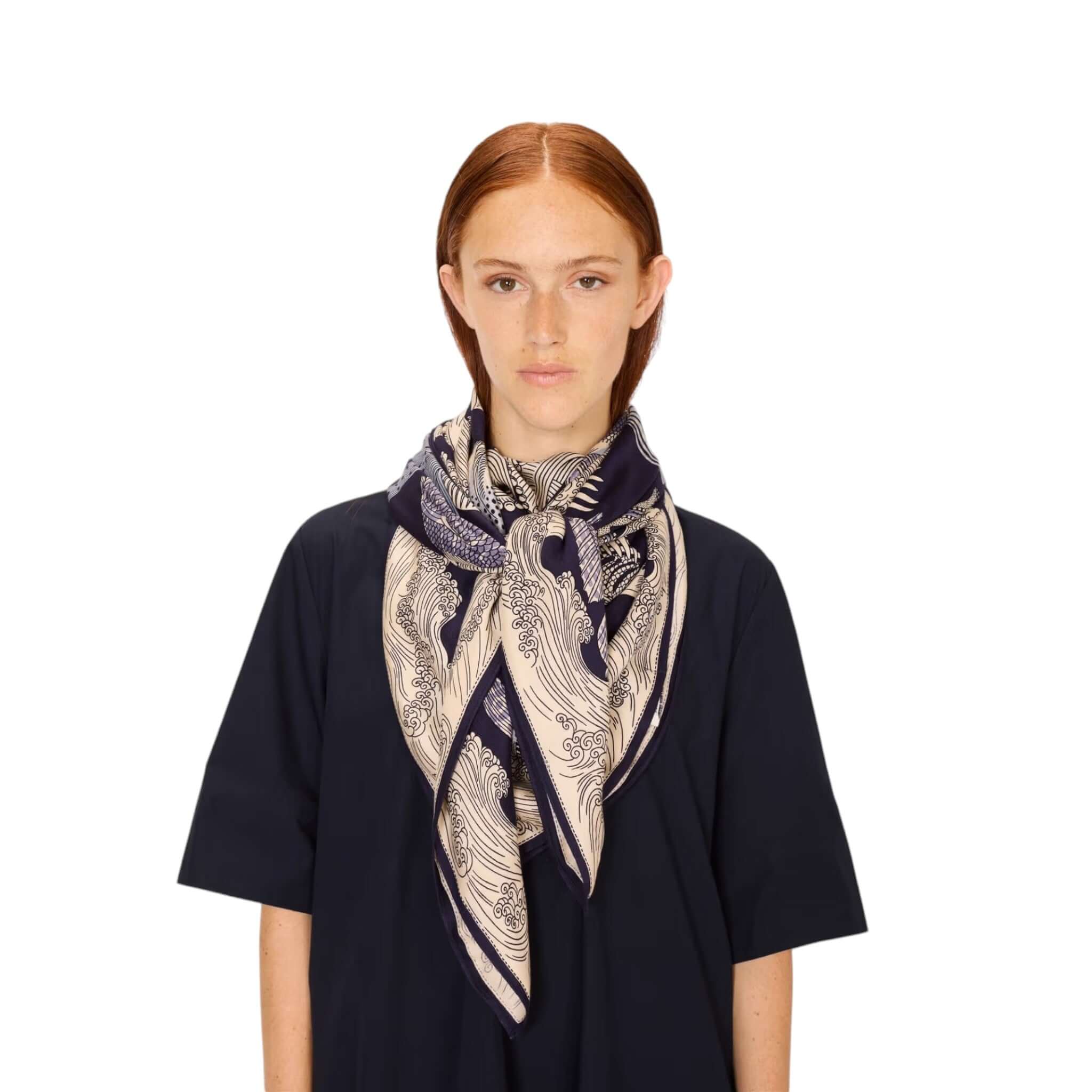 Foulard Quadrato Poseidon in seta modal, drappeggio sartoriale, indossato da donna con disegni elegantemente stampati.