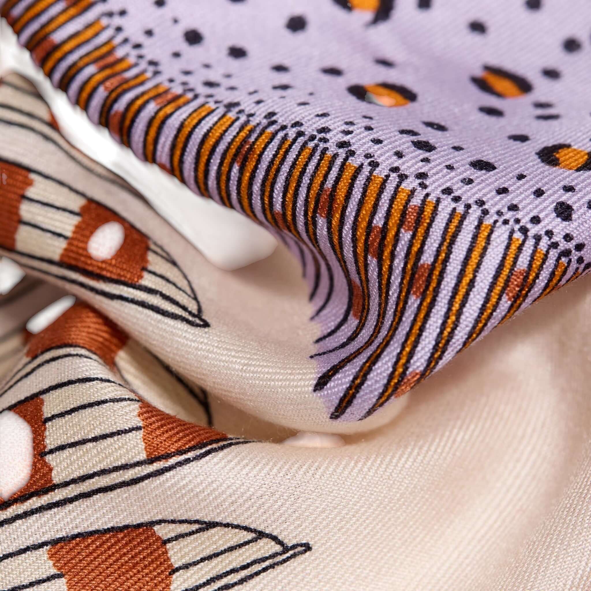 Close-up of Foulard Quadrato Poseidon, featuring vibrant colors and intricate patterns on luxurious modal silk.