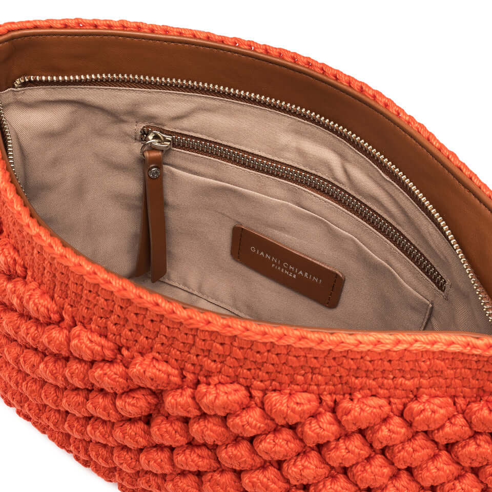 Interno della pouch Bella di Gianni Chiarini, tessuto lavorato a mano arancione con tasca piatta e chiusura a zip.