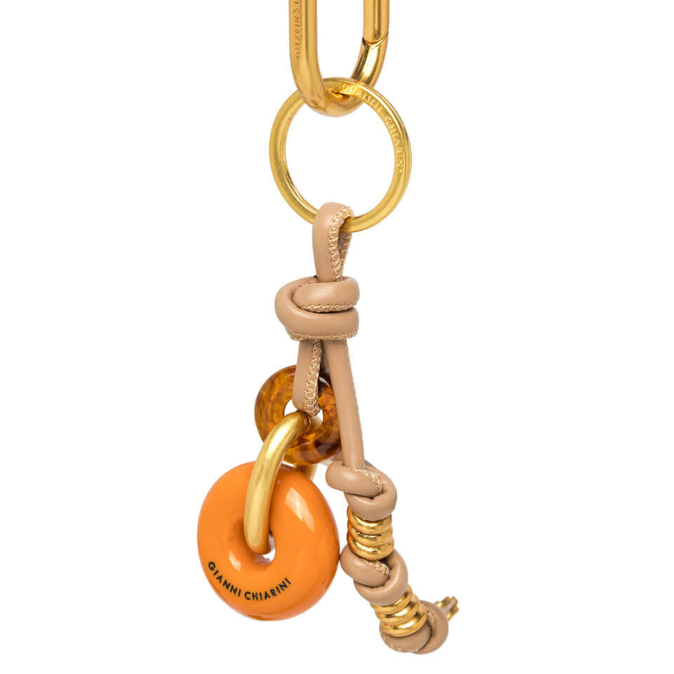 CHARM in leather and resin by Gianni Chiarini, a playful accessory for bags with a vibrant orange donut design.