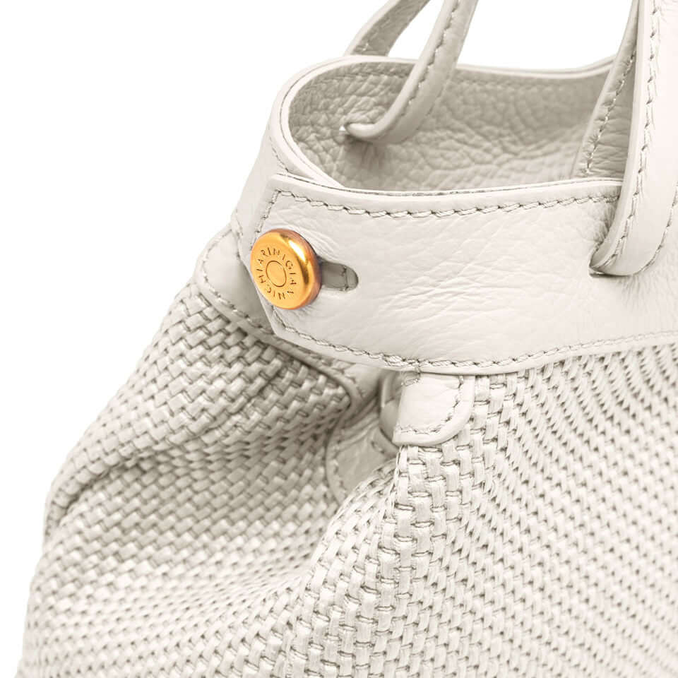 Close-up of Ottavia handbag by Gianni Chiarini, featuring woven straw fabric and an elegant logo detail.