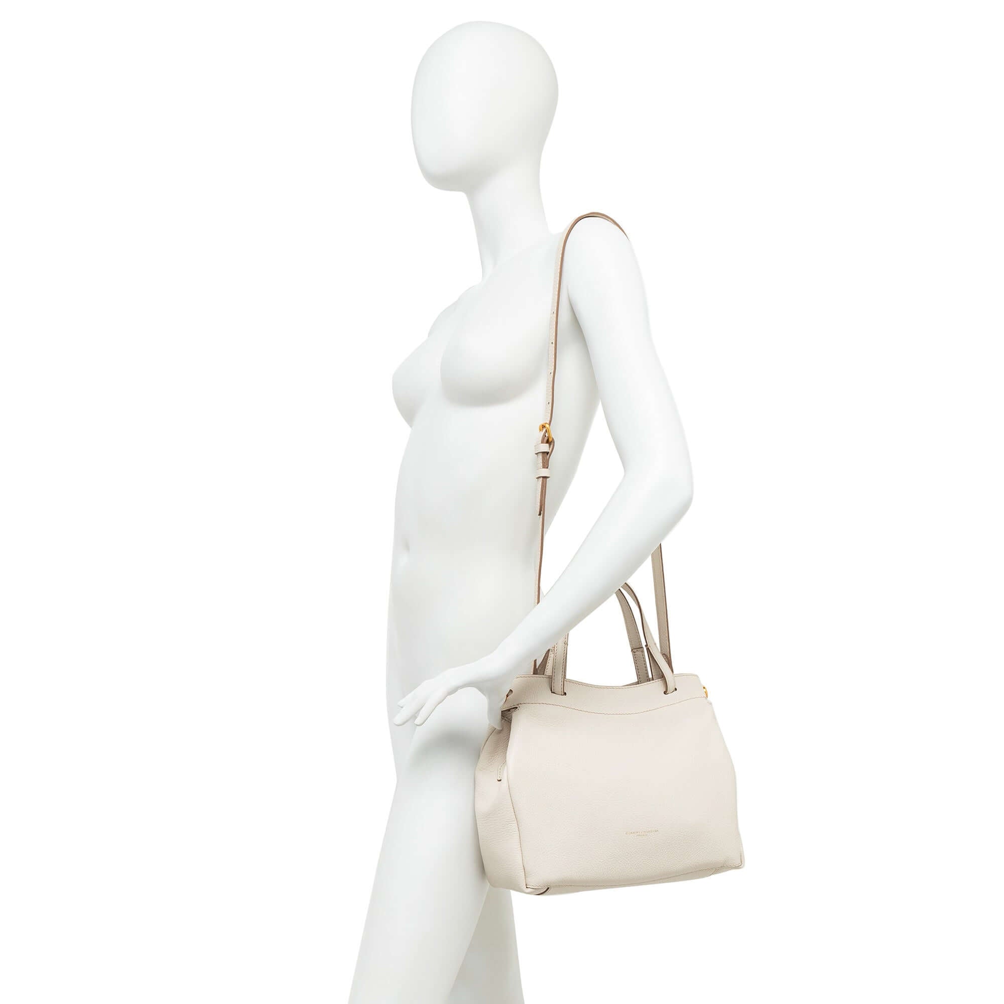 Model holding Ottavia leather bag by Gianni Chiarini, showcasing its dual carry options in a stylish beige shade.