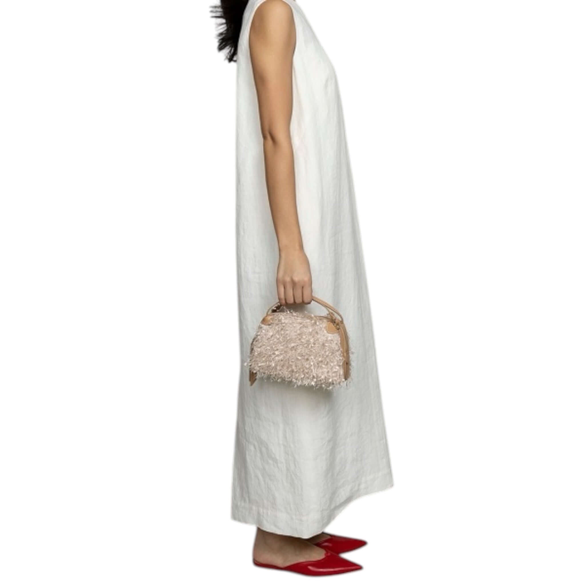 Modella con la borsa a mano ALIFA di Gianni Chiarini, tessuto sfrangiato e chiusura zip, ideale per utilizzo pratico.