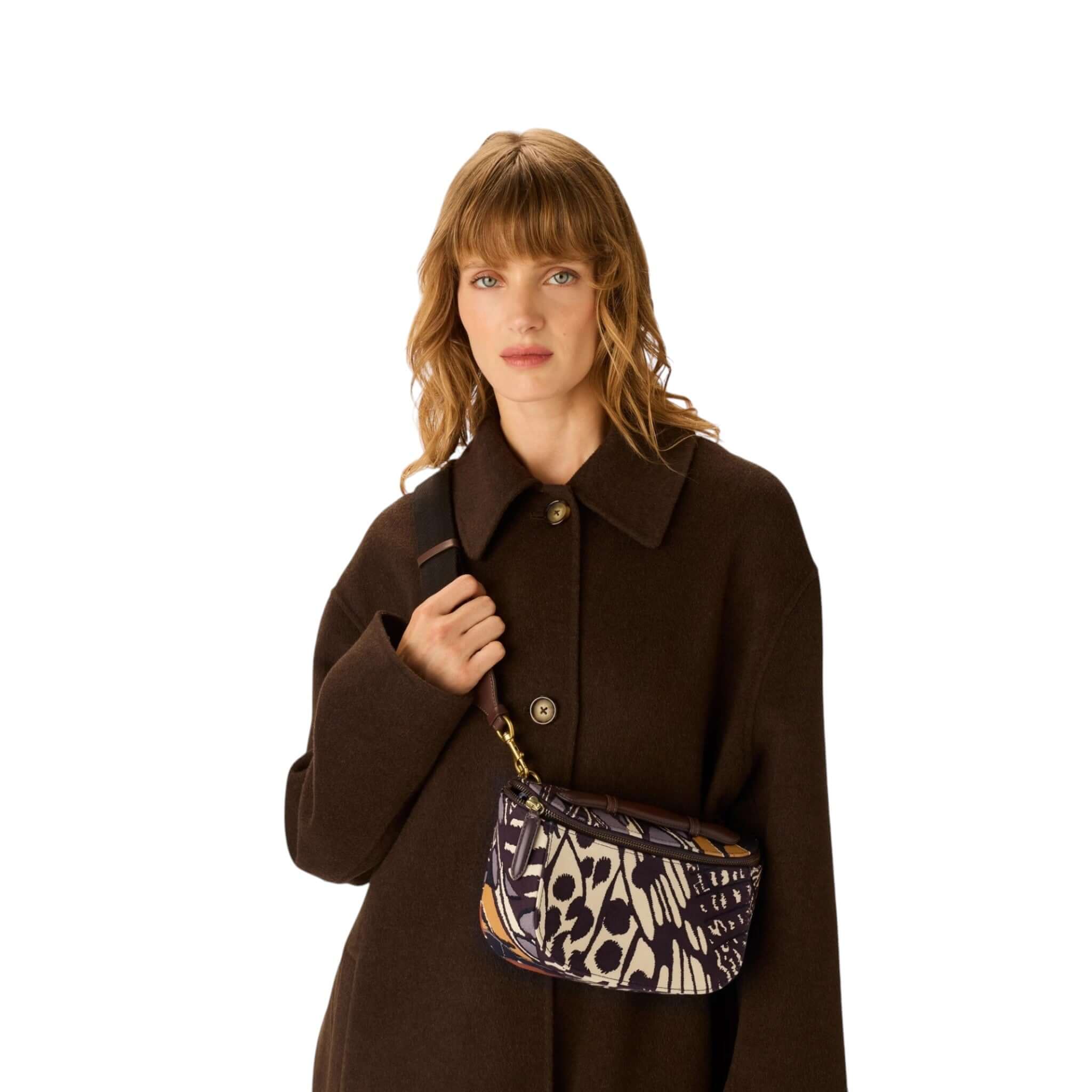 Borsa a tracolla Gabriel Farfalle indossata da una modella con cappotto scuro e fondo bianco.