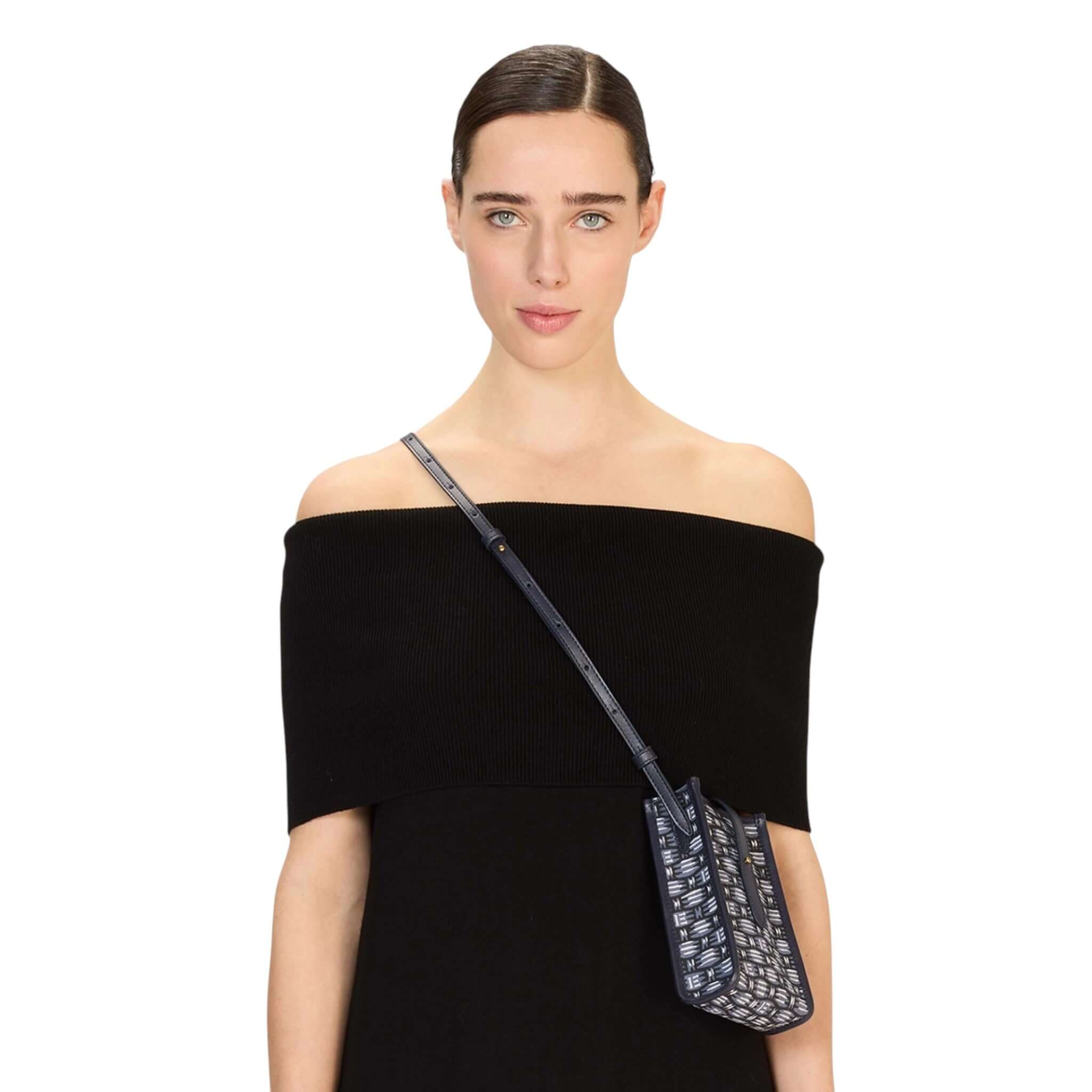 Custodia Caprice Cannage indossata da una modella con abito nero, caratterizzata da design iconico e tracolla regolabile.