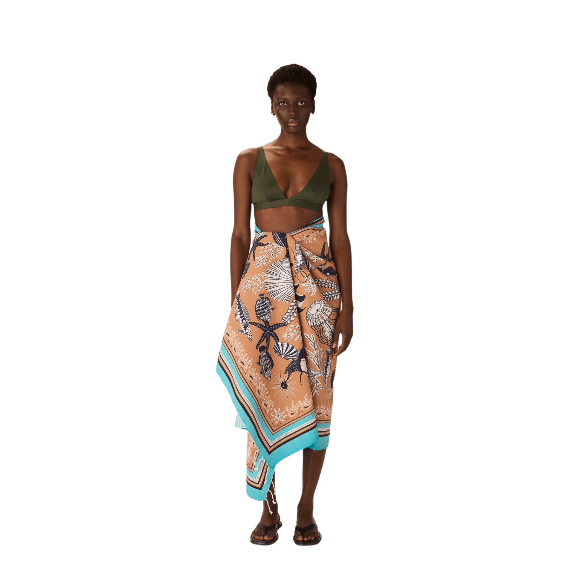 Modella che indossa un pareo in cotone, ideale per l'estate, con motivi tropicali, perfetto come asciugamano da spiaggia in cotone.