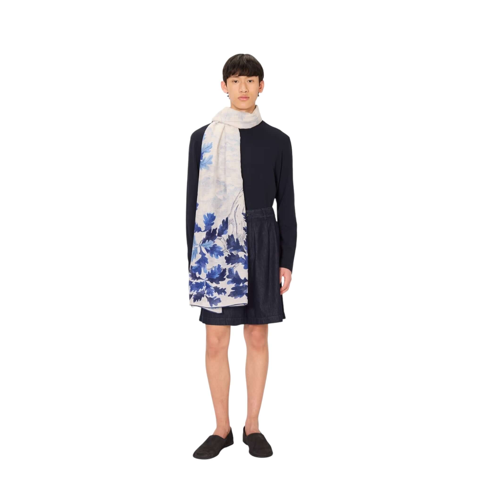 Elegante sciarpa Amboise stampata a mano, indossata da un modello, in colori blu su sfondo chiaro.