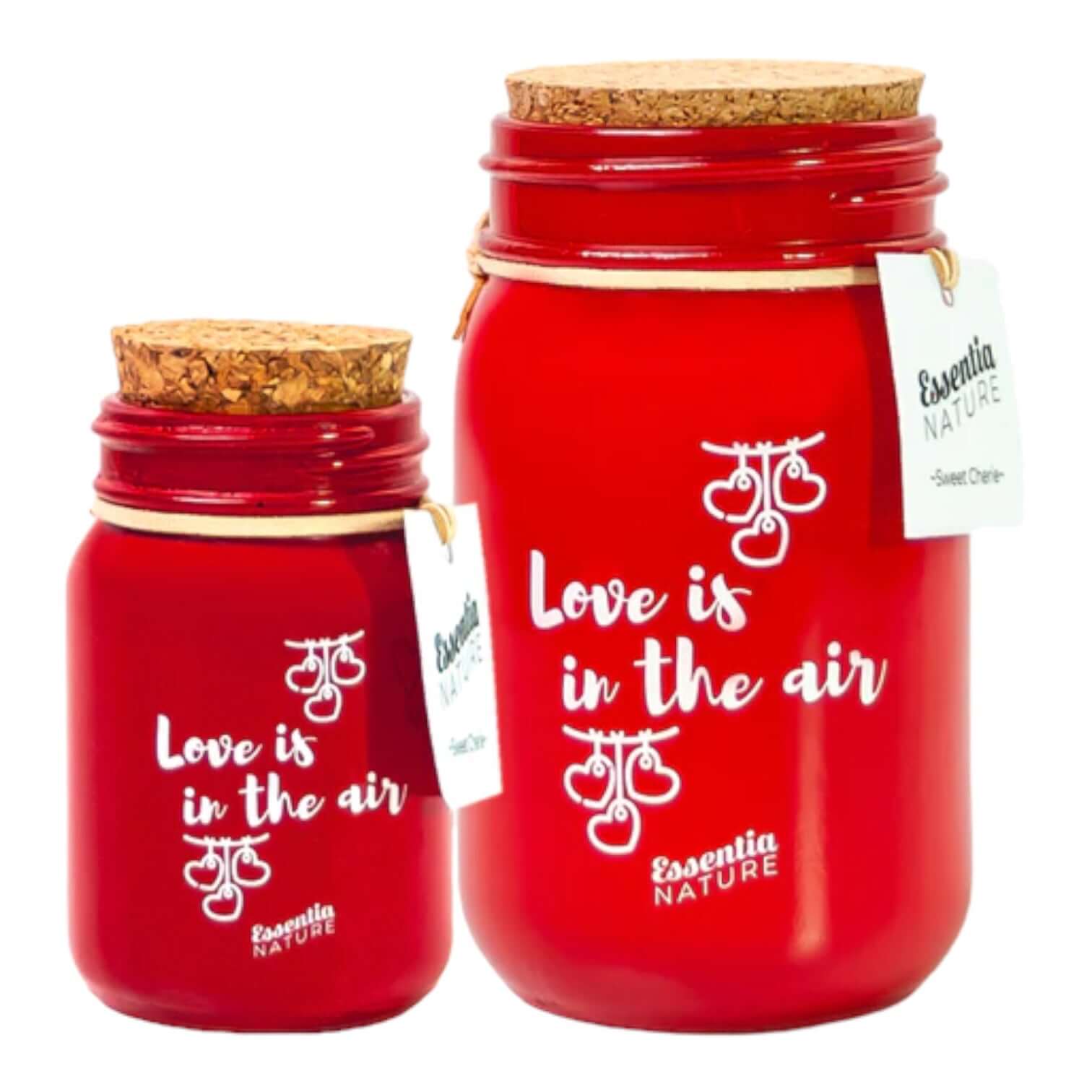 Two red scented candles from Essentia Nature with cork lids, labeled 'Love is in the air' and 'Sweet Cherie'.