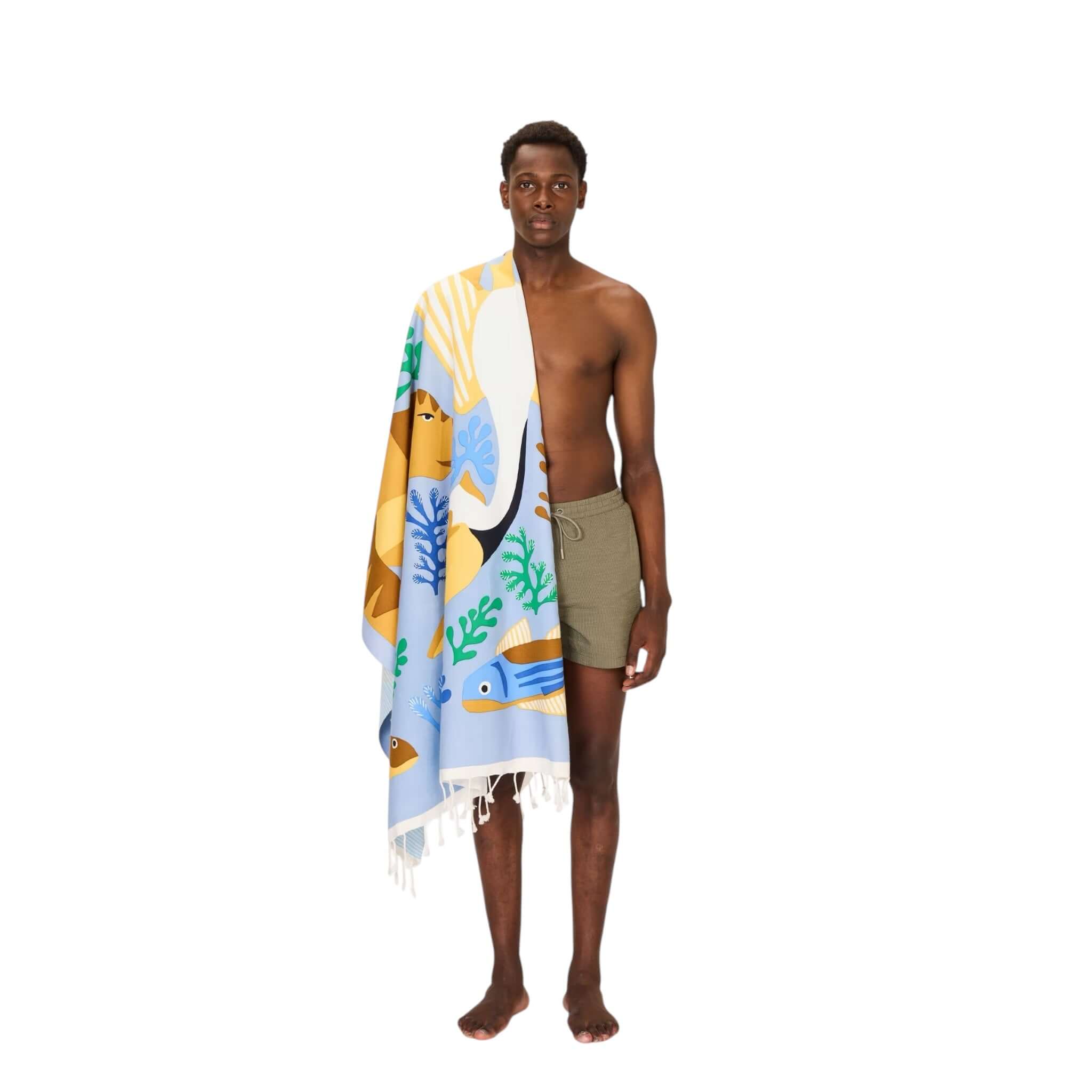 Man holding Telo Mare Splash beach towel featuring vibrant hand-printed designs inspired by nature.