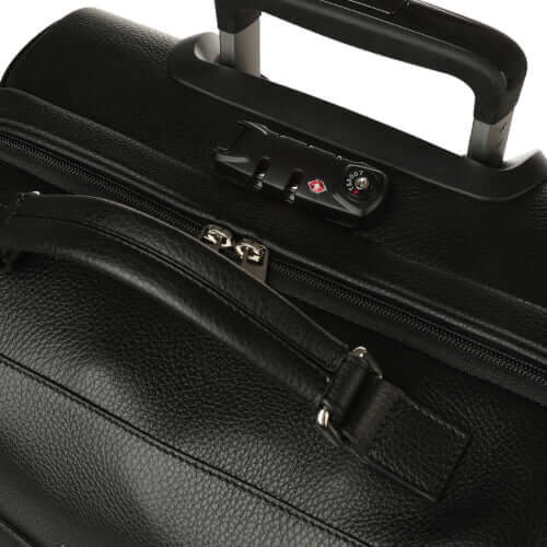 Dettaglio trolley da viaggio in pelle, scompartimenti, chiusura sicura con codice e manico per il trasporto.