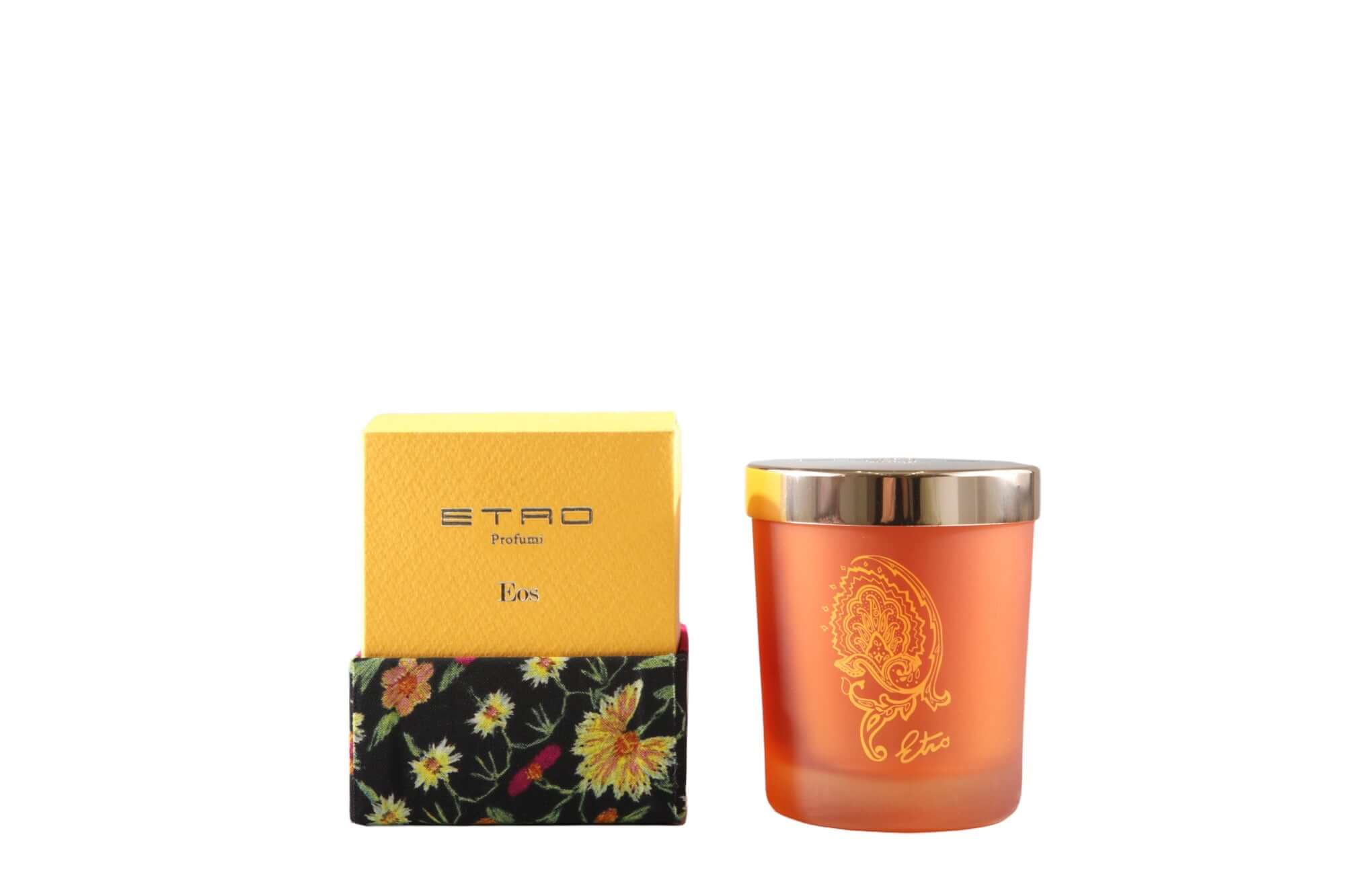 Eos Candela in orange glass with gold lid, ETRO branding, and floral packaging, 170g fragrance.